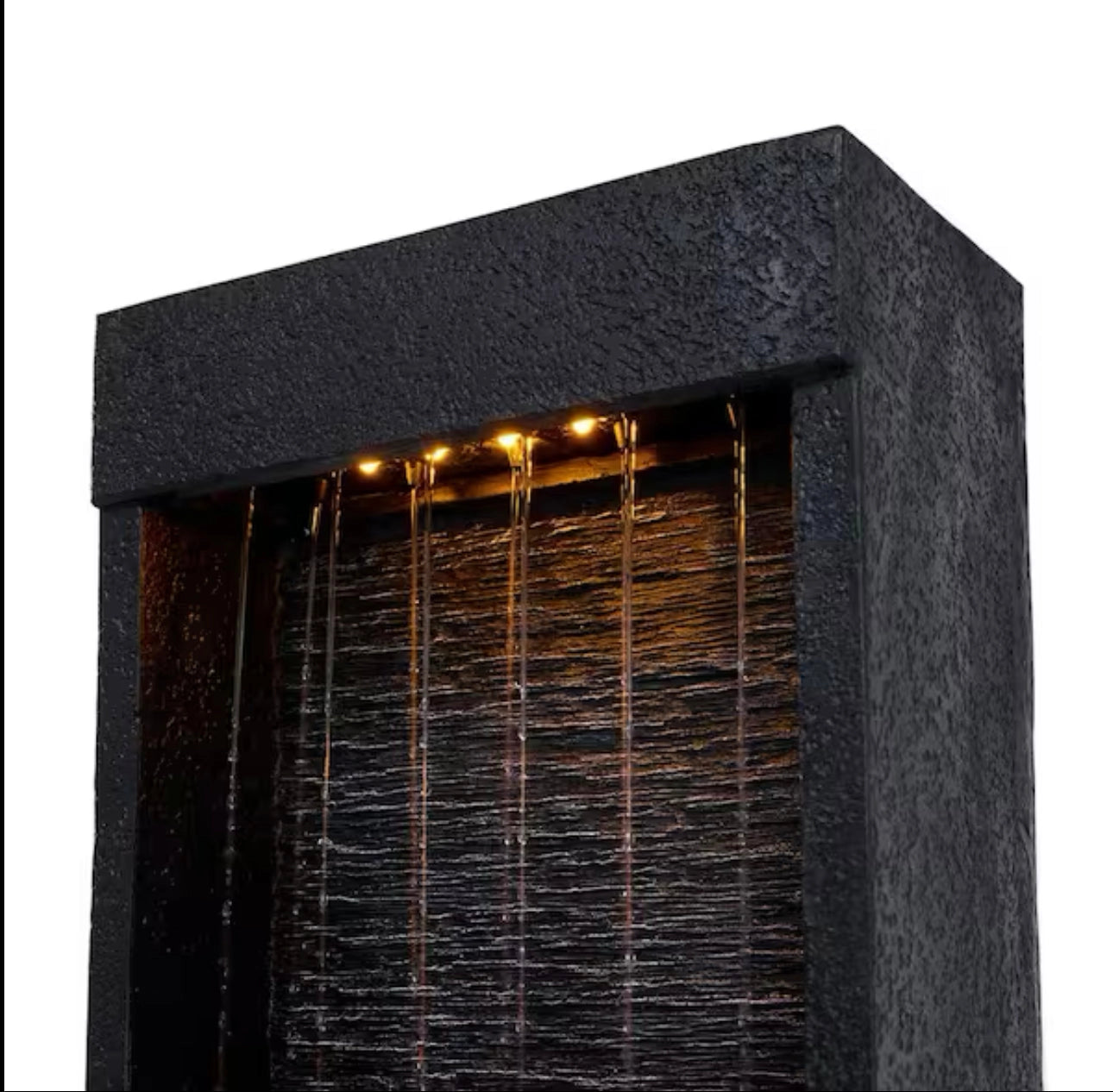 38-inch solar-powered gray slate waterfall fountain with LED lights placed outdoors near a building facade with windows and doors.