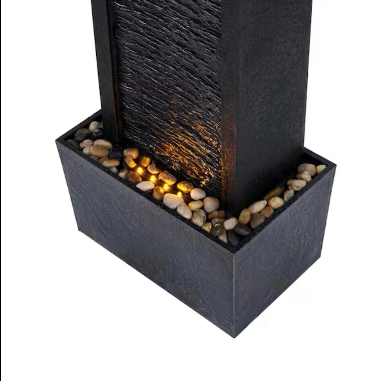38-Inch solar-powered gray slate waterfall fountain with LED lights on a wooden floor with metal and glass elements in the background.