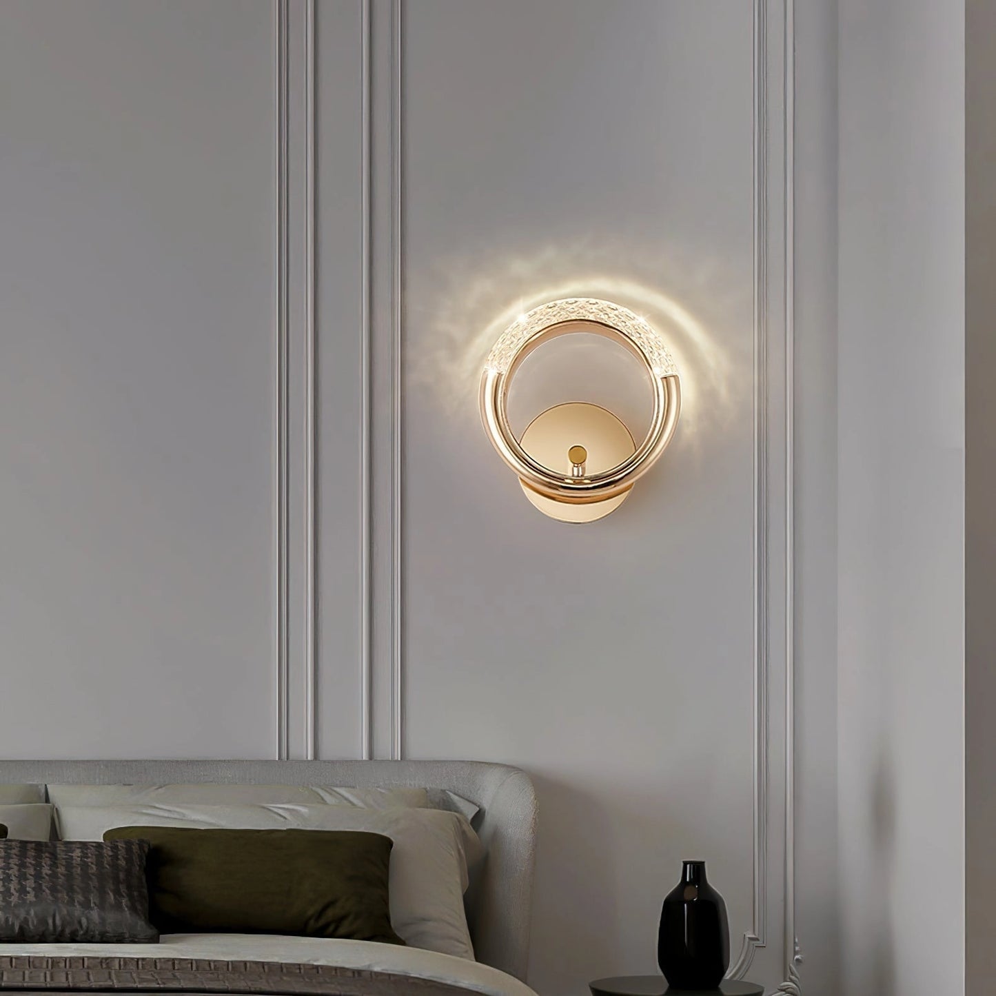 Luxurious metallic wall lamp with an adaptable angle and rotatable design, mounted on a white and grey wall, featuring a modern interior design with wooden elements, a comfortable pillow, and rectangular shapes.