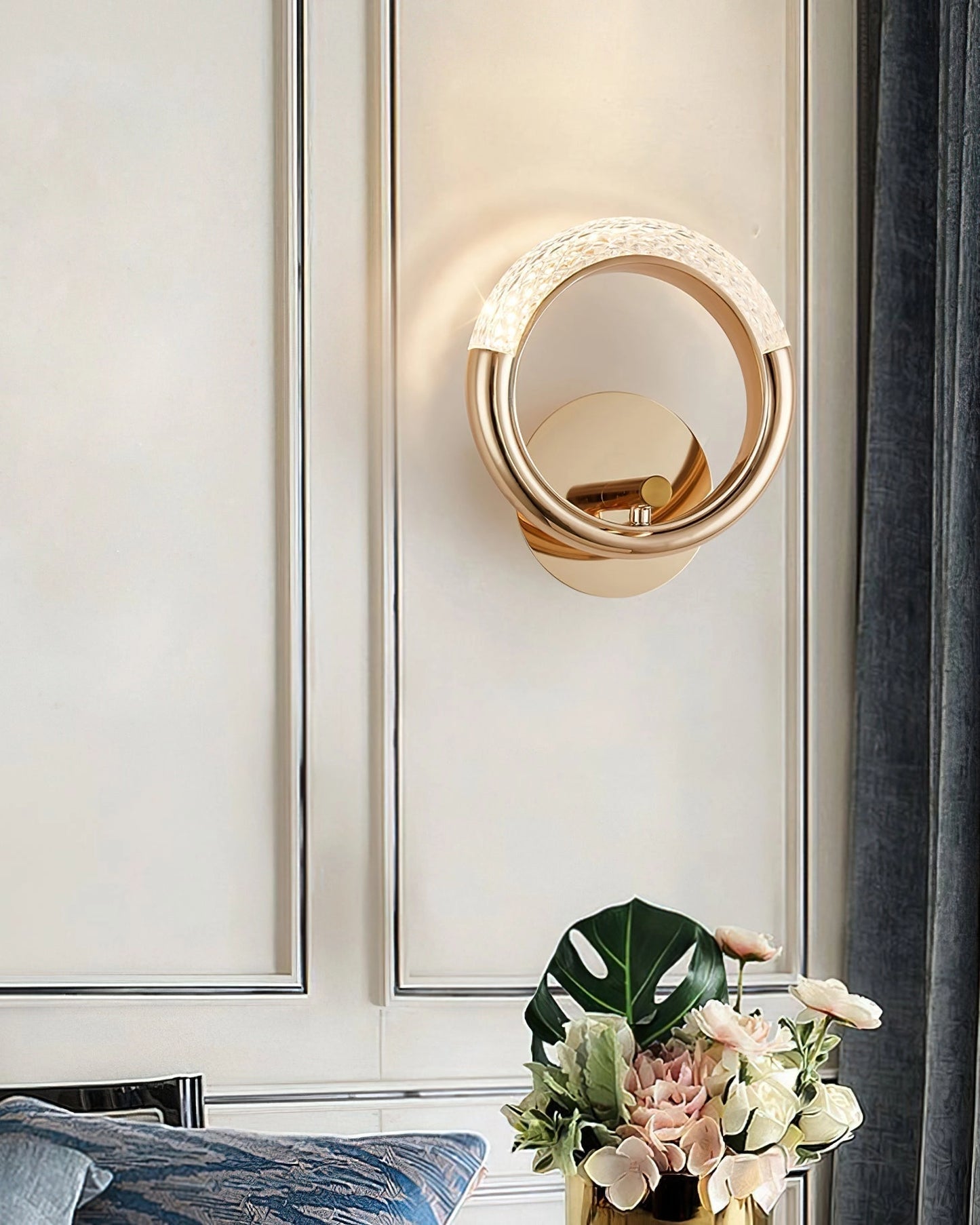 Luxurious metallic adaptable angle rotatable wall lamp mounted on a wooden wall in a well-designed interior room with a rectangular mirror and a door.