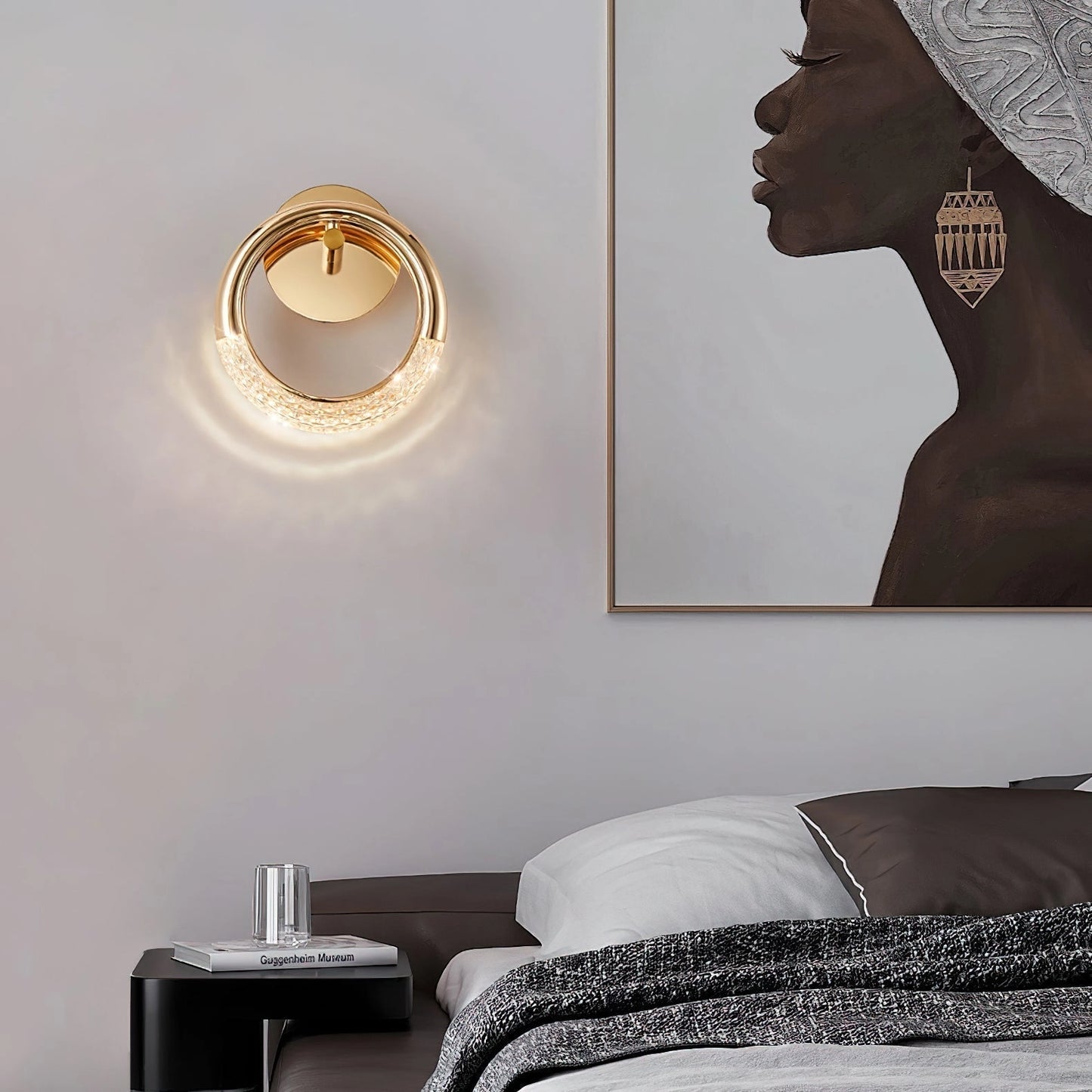 Luxurious metallic rotatable wall lamp with adaptable angles, mounted on a grey wall in a modern room with wooden accents and artistic decor.