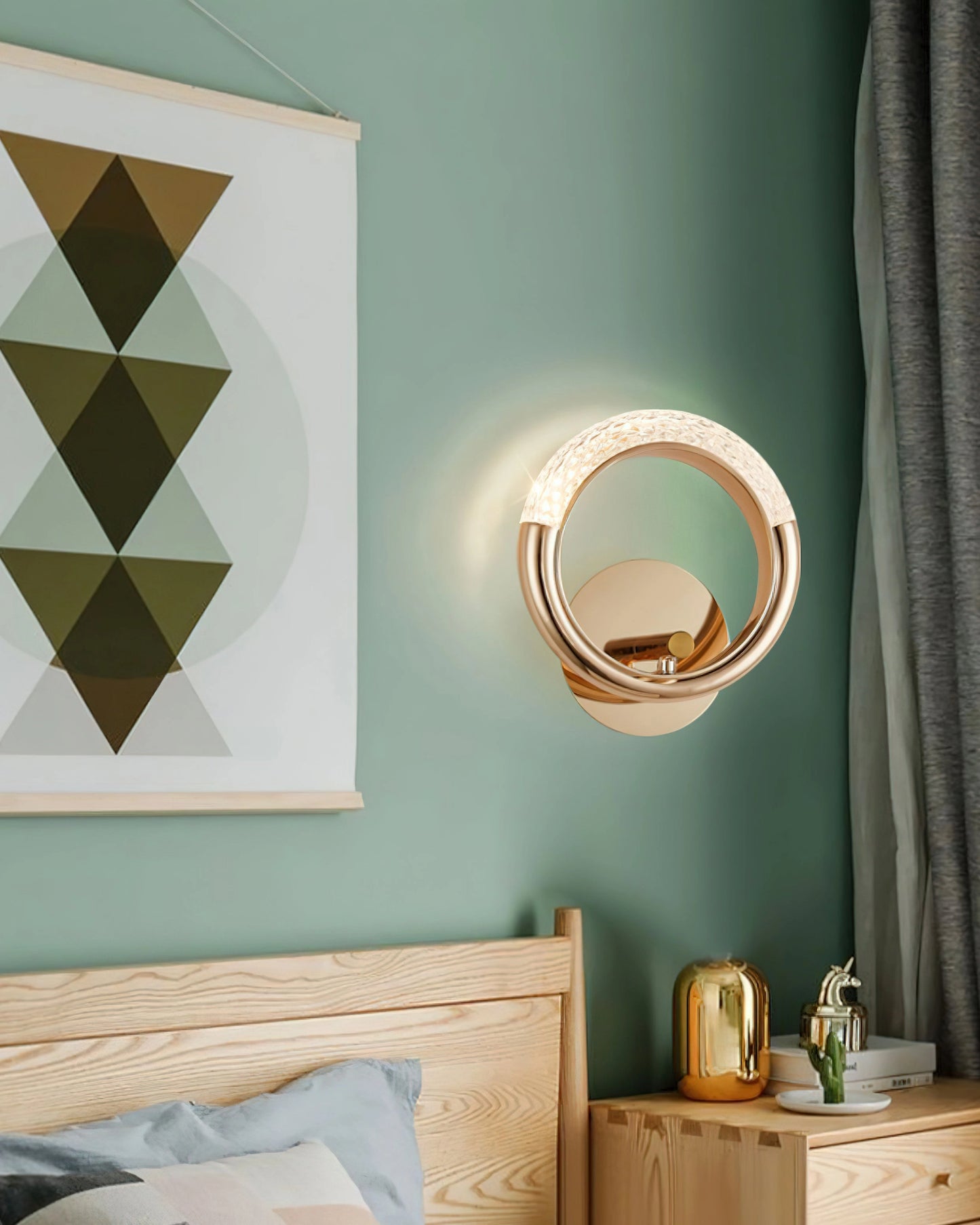 Luxurious metallic rotatable wall lamp with adaptable angle feature mounted on a white wall near a wooden cabinet with drawers, mirror, and green accents.