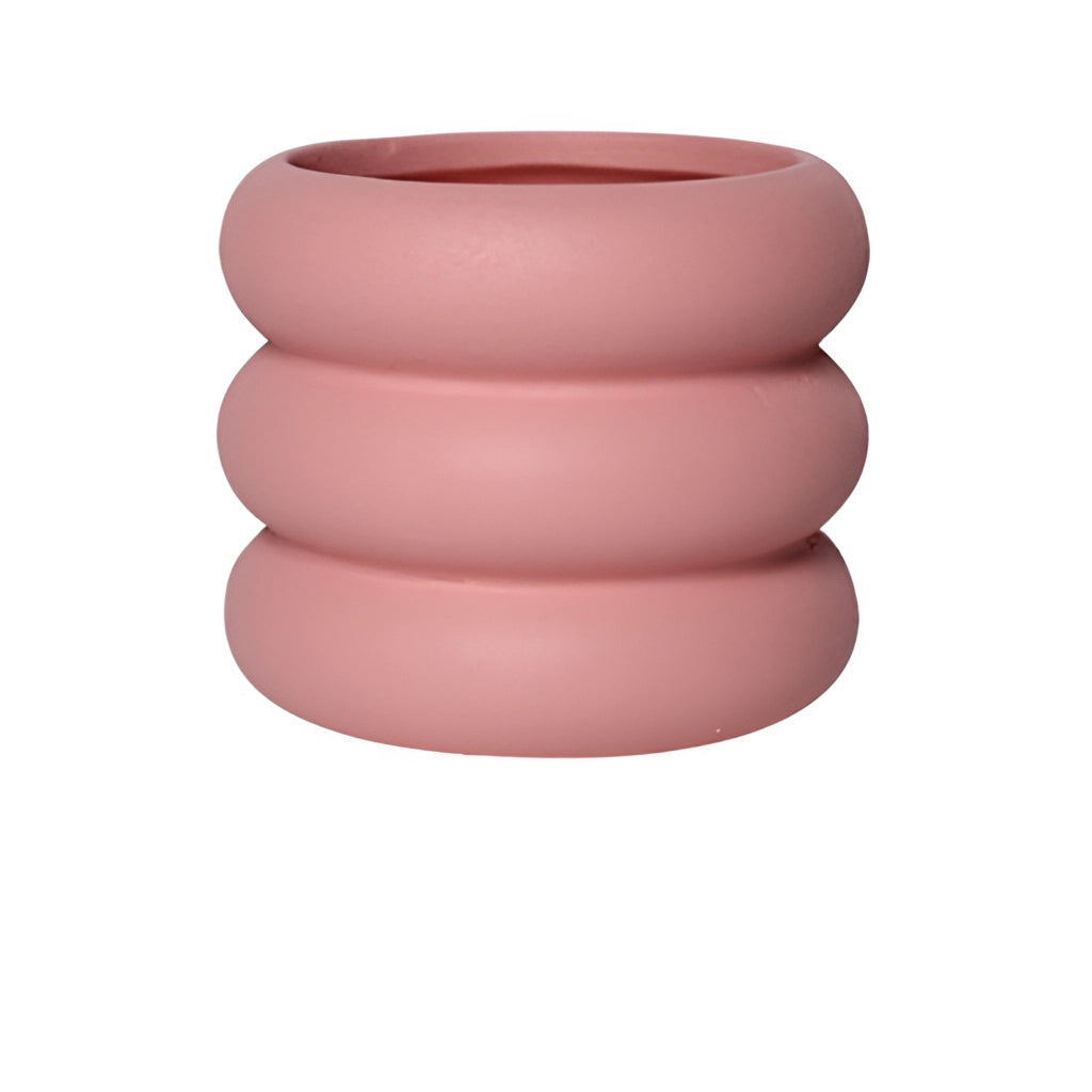Large pink ceramic round plant pot on display.