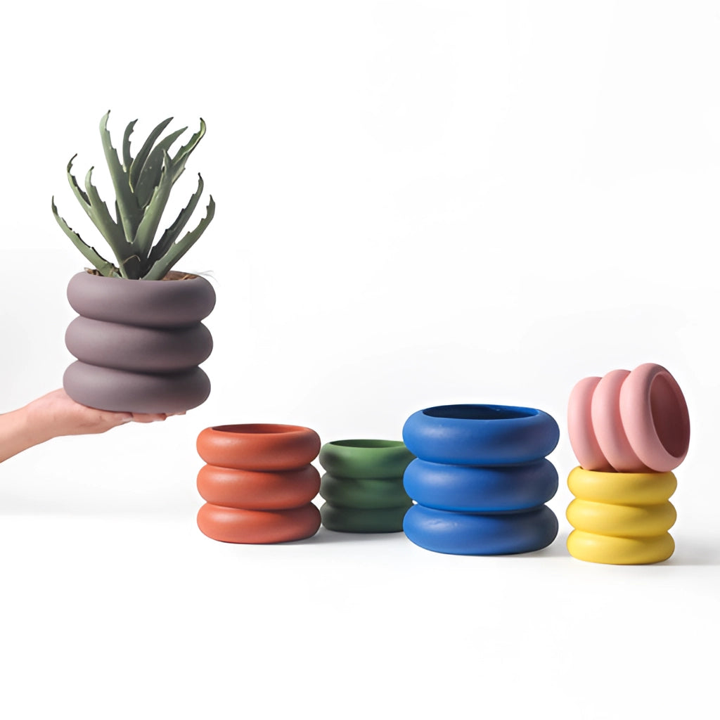 A ceramic round plant pot displayed on a wooden surface, suitable for holding terrestrial plants.