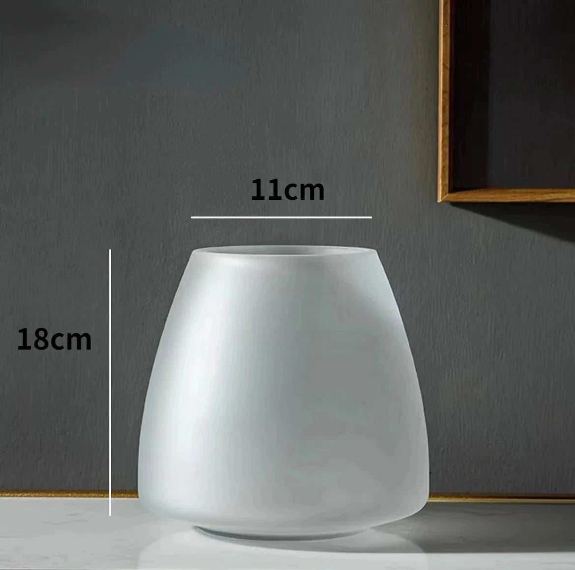 Coffee-colored frosted glass vase with a rectangular shape placed on a table.