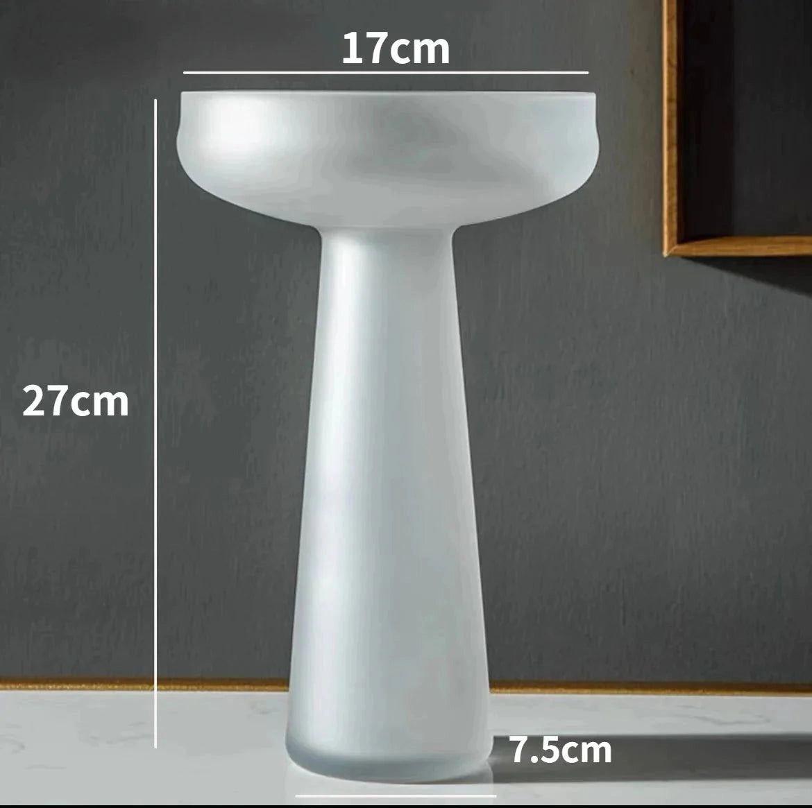 A coffee-colored frosted glass vase sitting on a table.