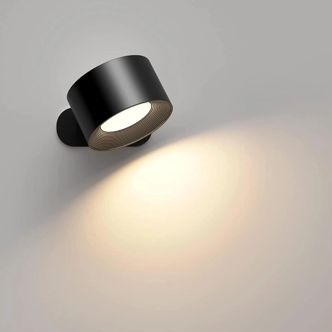 Cordless LED wall lamp in black with adjustable brightness and color modes, featuring a sleek cylindrical design and a circular lamp lens.
