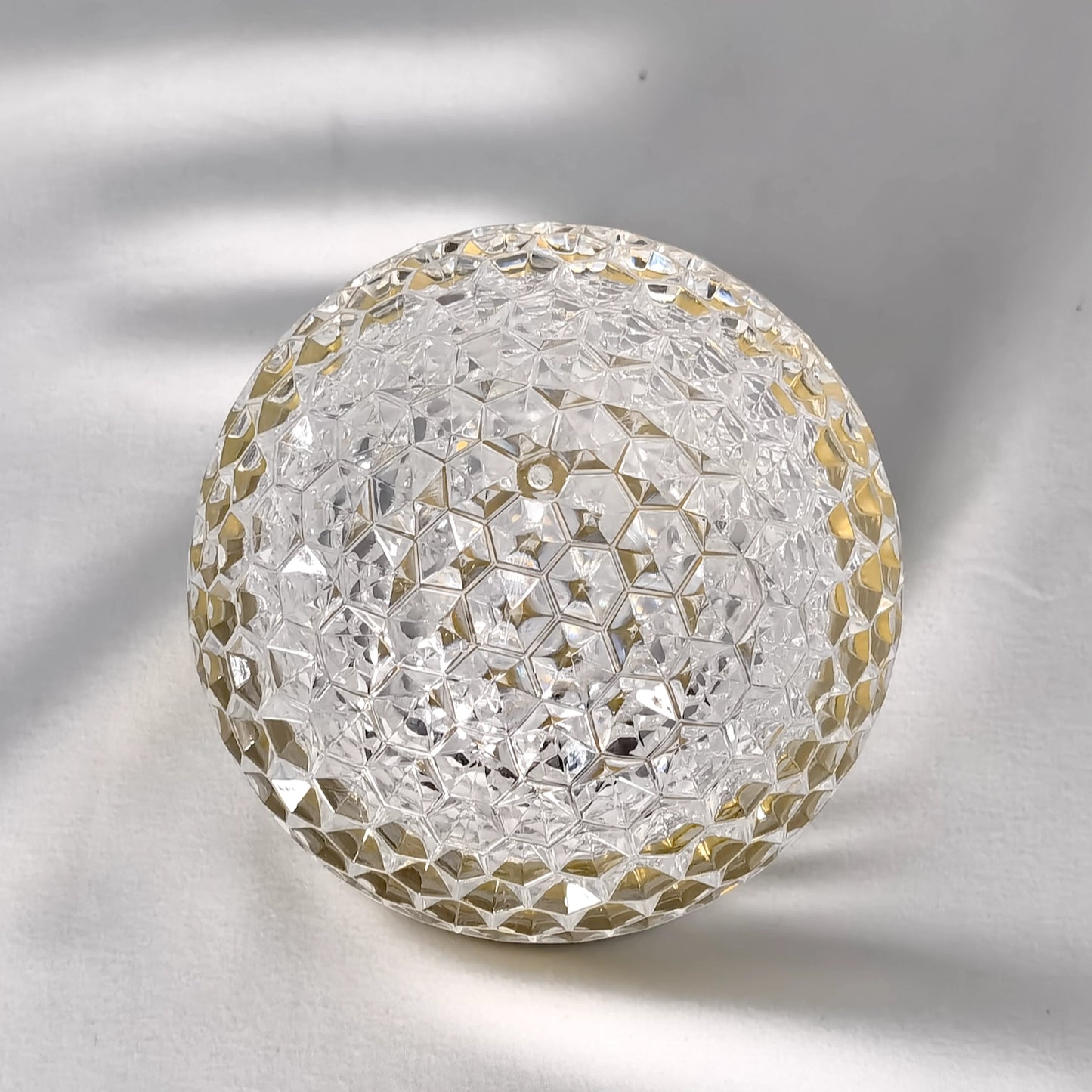 Cordless Rechargeable Table Lamp LED Dimmable Light in Modern Design on a table. The lamp features a sleek, silver finish and circular patterns, blending well in a contemporary setting.