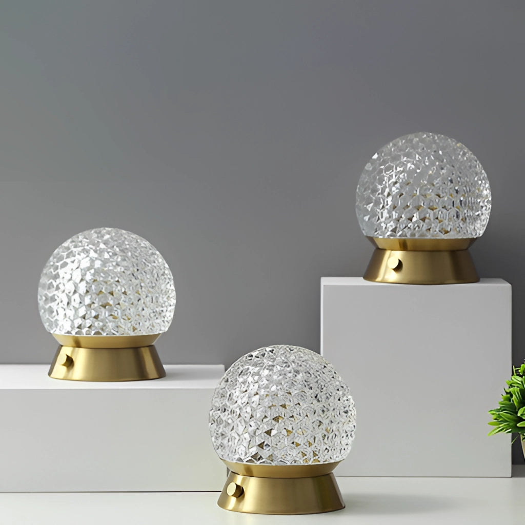 Modern cordless rechargeable LED table lamp with dimmable light, featuring a sleek silver finish, placed on a table next to a small green plant.
