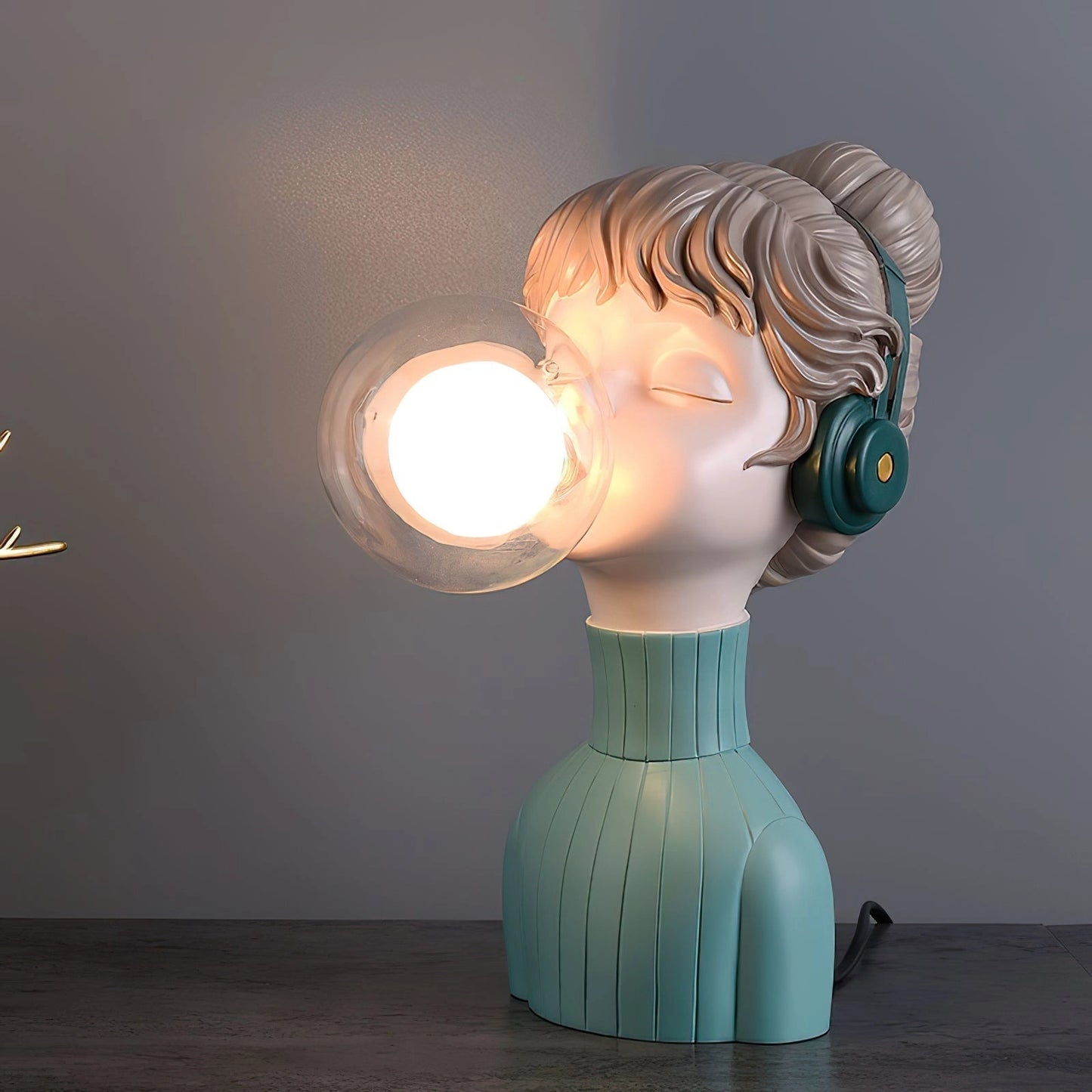 Orange and green chic minimalist desk lamp from the Resin Series, featuring a unique design with a figurine resembling a fictional character, positioned on a wooden base.