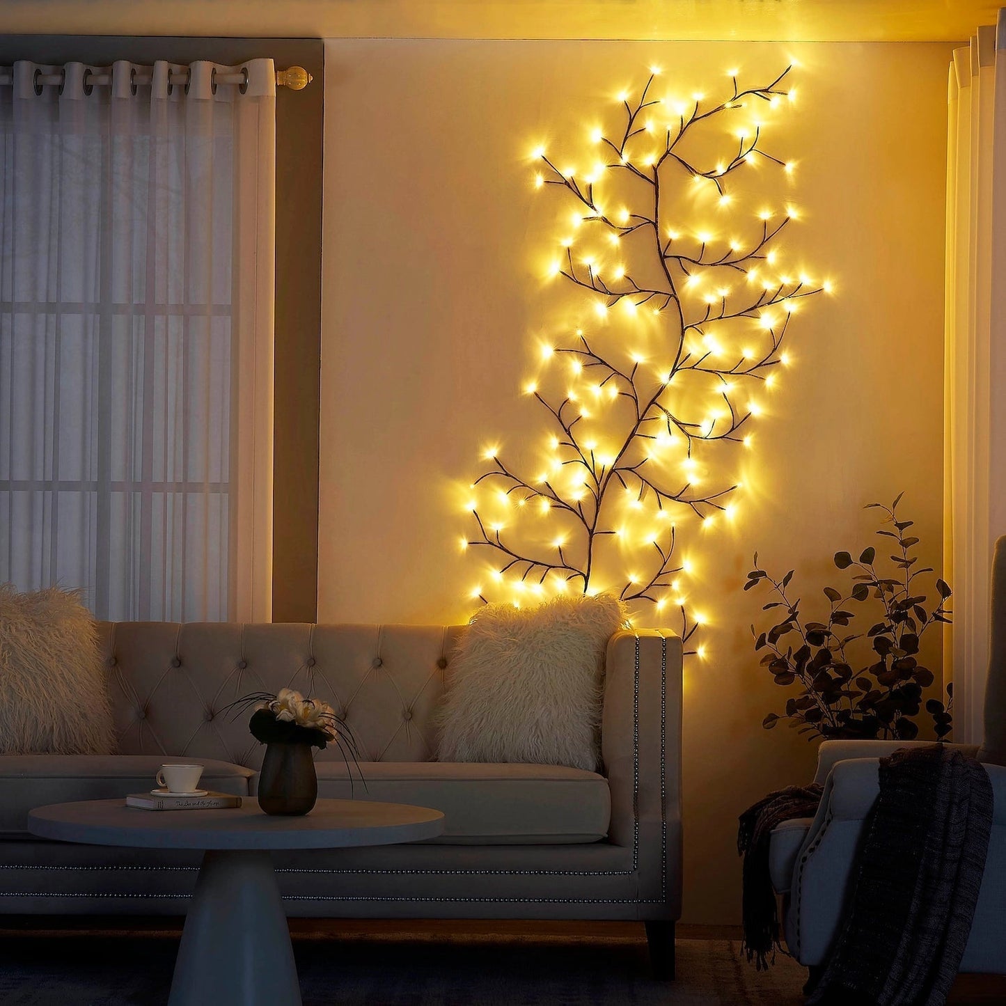 Enchanted Willow Vine Light Freya illuminating a living room with its tranquil and decorative wooden branches, creating a serene interior design ambiance.