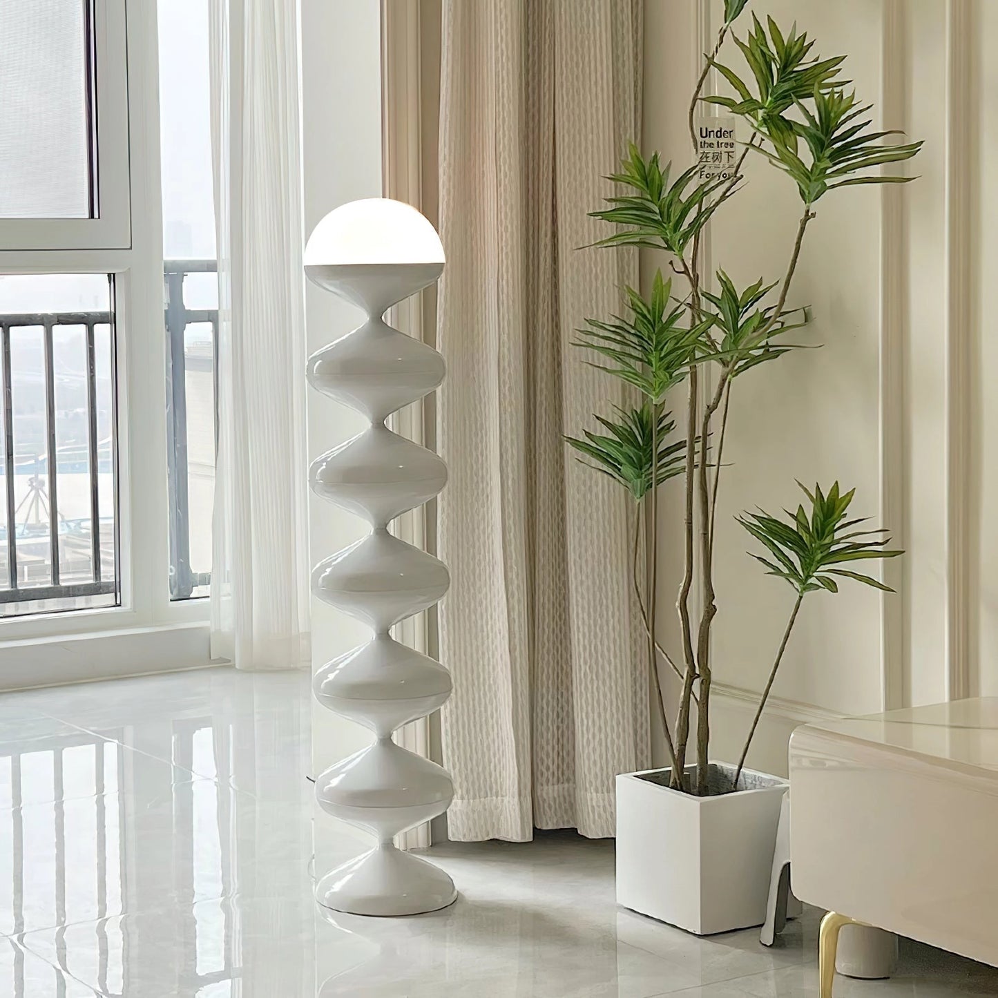 Modern elegant floor lamp with twisted gourd design next to a wooden side table, houseplant, and large window in a stylish interior setting.