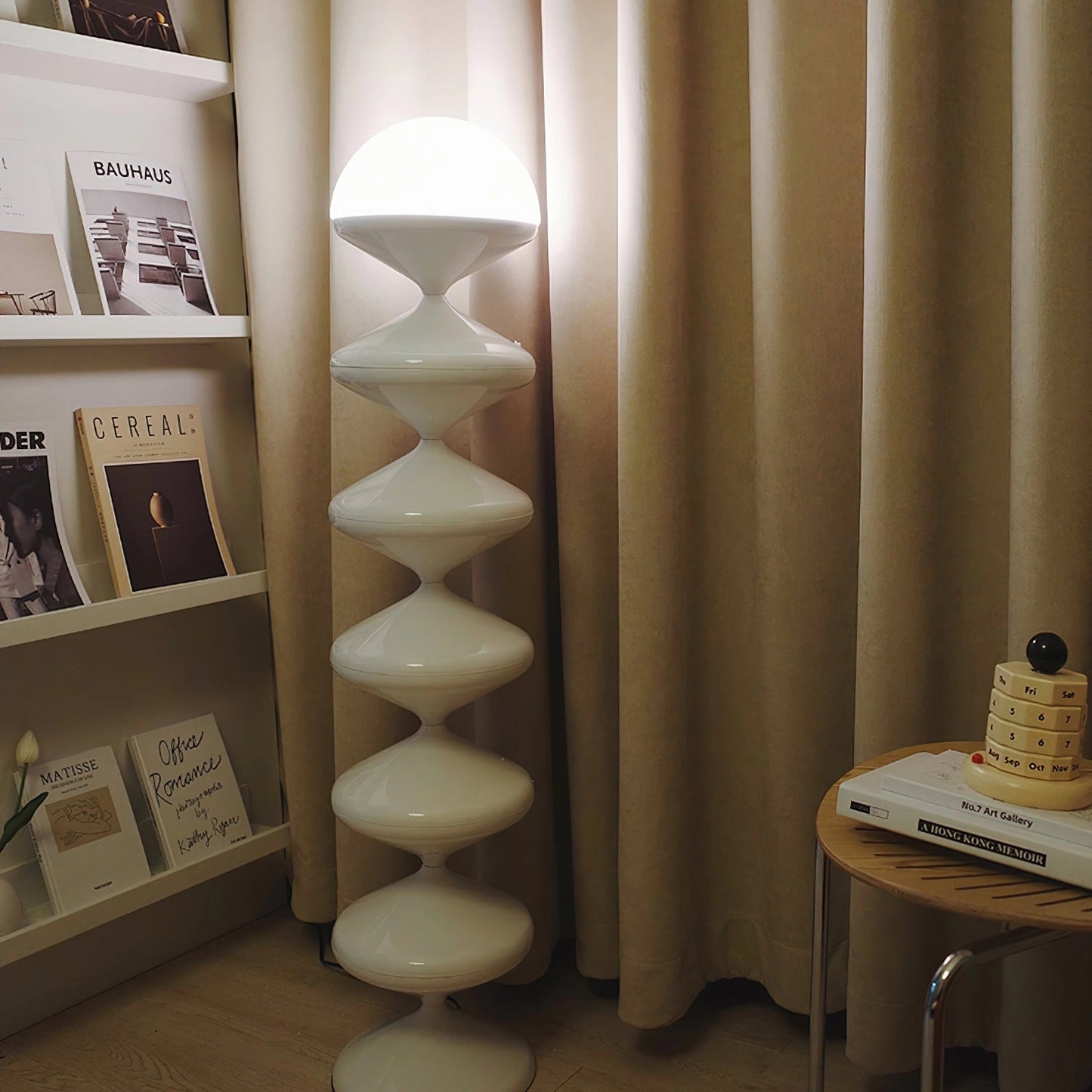 Modern elegant floor lamp with twisted gourd design, featuring a wooden base, set in a beige interior with hardwood flooring.