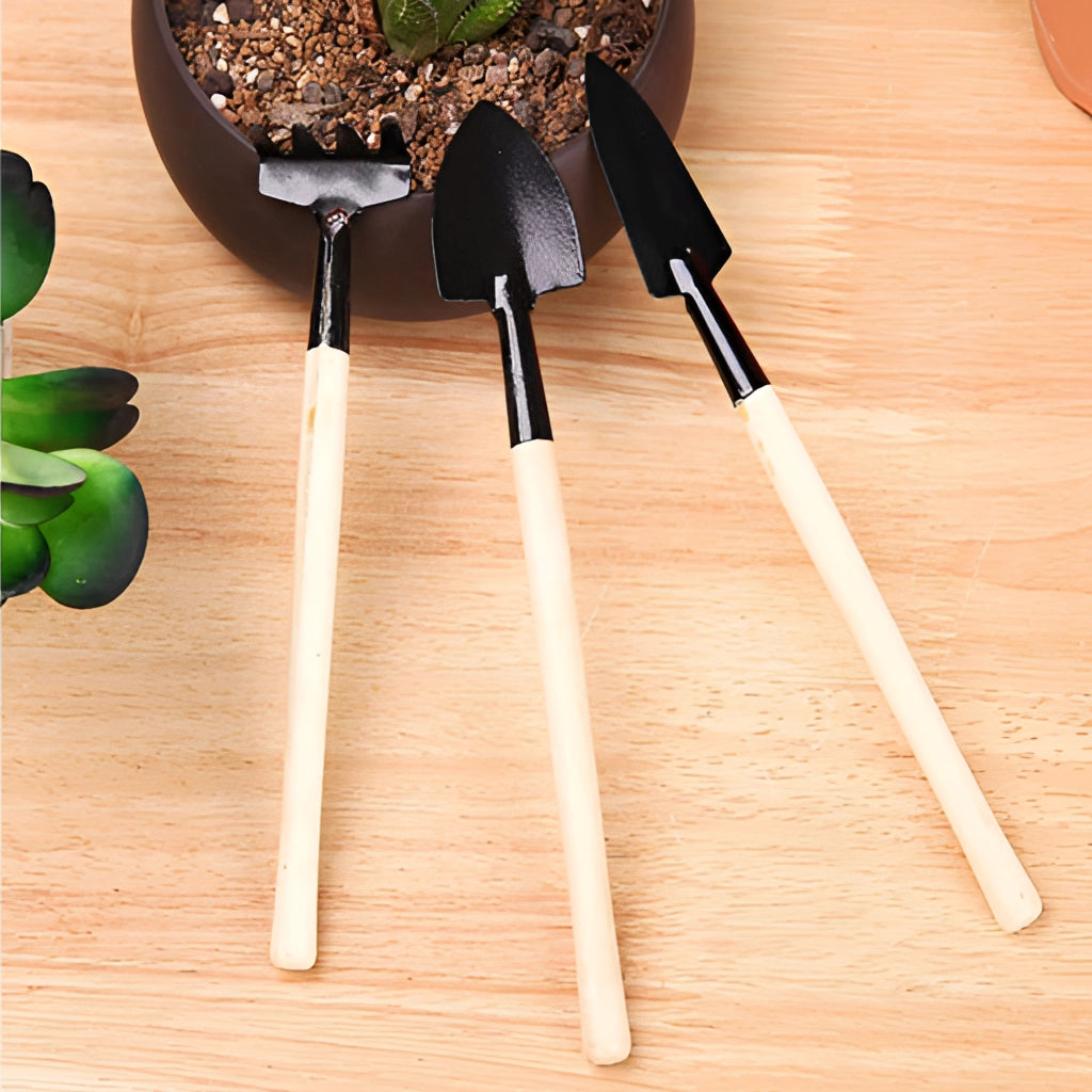 Gardening tool set with durable iron blades and wooden handles placed on a rustic wooden surface.