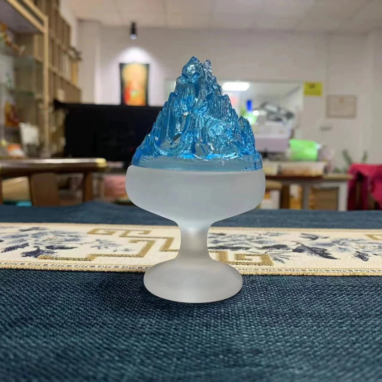 A glass incense burner with a sleek, transparent design placed on a table, illuminated by soft lighting, ideal for Zen home decor.