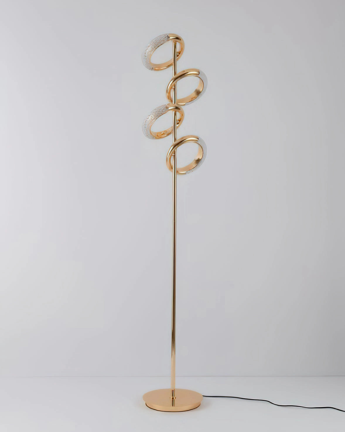 Gold diamond-patterned adjustable angles floor lamp next to a potted plant and wall art.