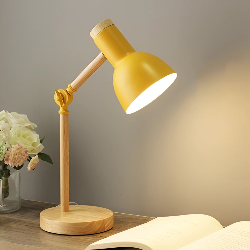 LED desk lamp with Scandinavian minimalist design in yellow, featuring three color settings and a switch, placed on a wooden table next to a vase with flowers and a small plant for a comfortable and balanced aesthetic.