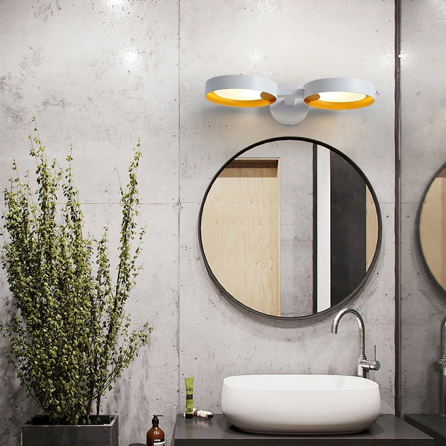 A contemporary LED wall light with an artistic design made of iron and acrylic, mounted on a wall above a white sink and tap, with a mirror reflecting the light and a small plant adding a touch of greenery.