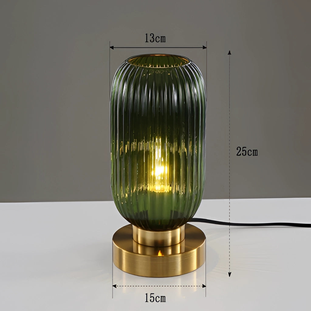 A 13cm green luminescent crystal table lamp with a cylindrical shape, featuring a combination of glass and metal elements, including aluminum, with a transparent finish.