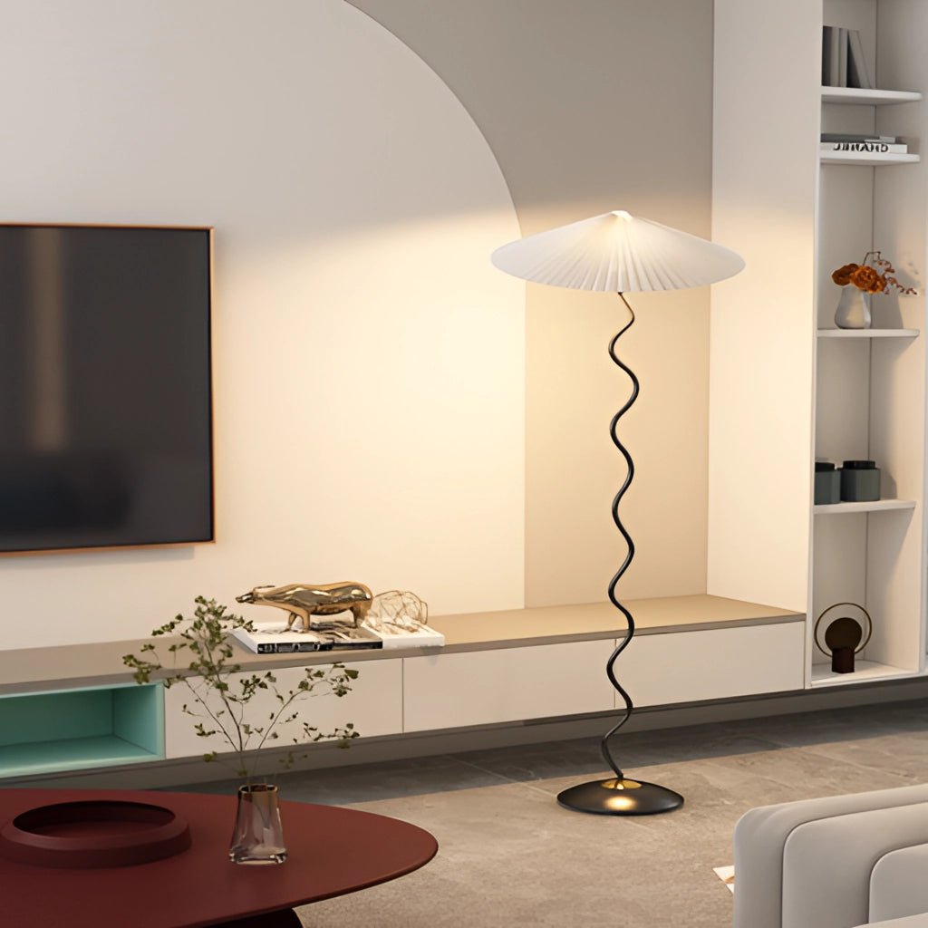 A Metal Textile Curved Pleated Floor Lamp placed in a modern living room setting with wooden flooring and contemporary furniture.