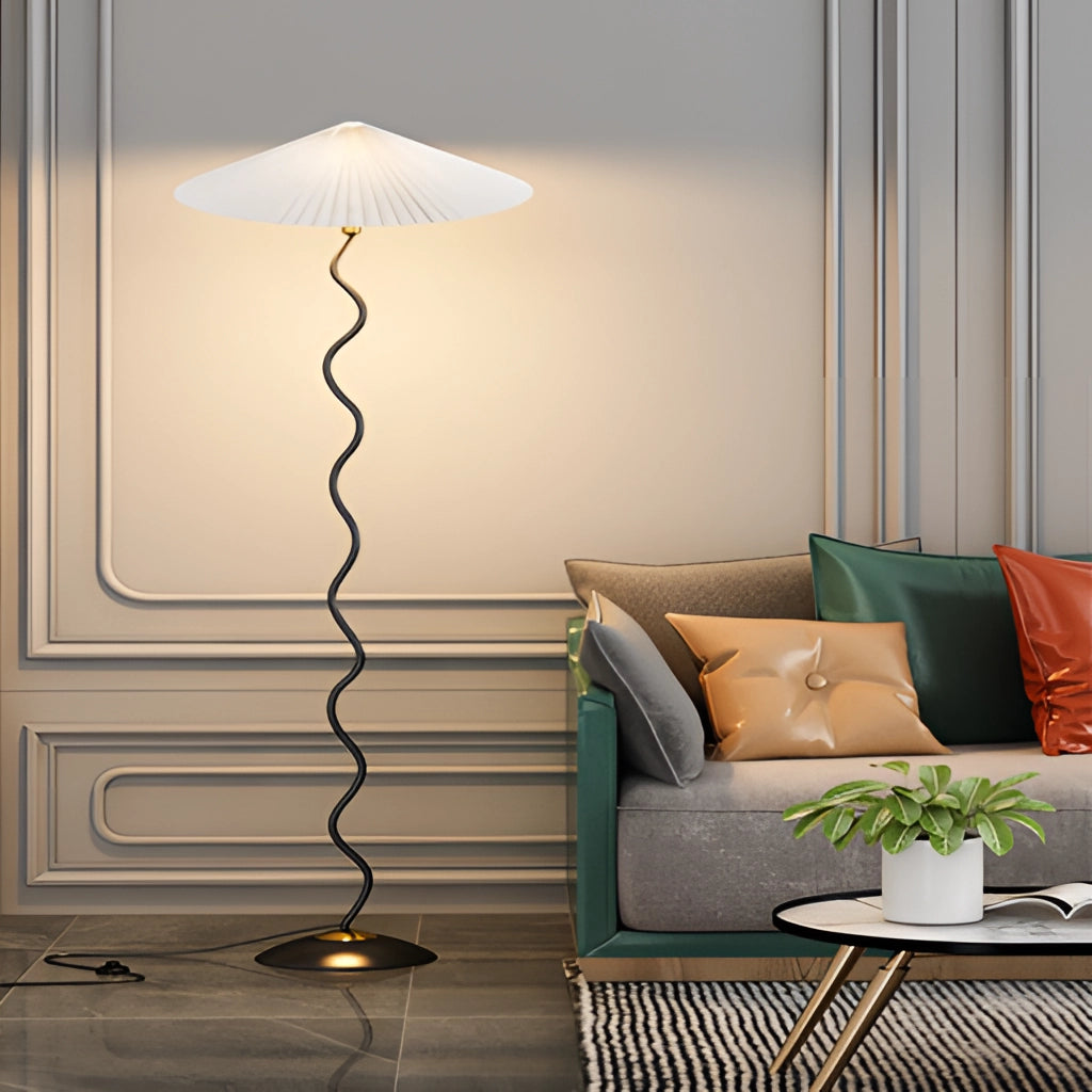 A modern Metal Textile Curved Pleated Floor Lamp placed in a stylish living room with a white couch and grey accents.