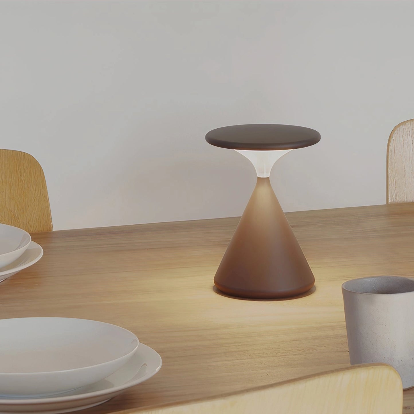 Outdoor cordless lamp on a beige wooden table with elegant tableware and serveware in a stylish interior design setting.