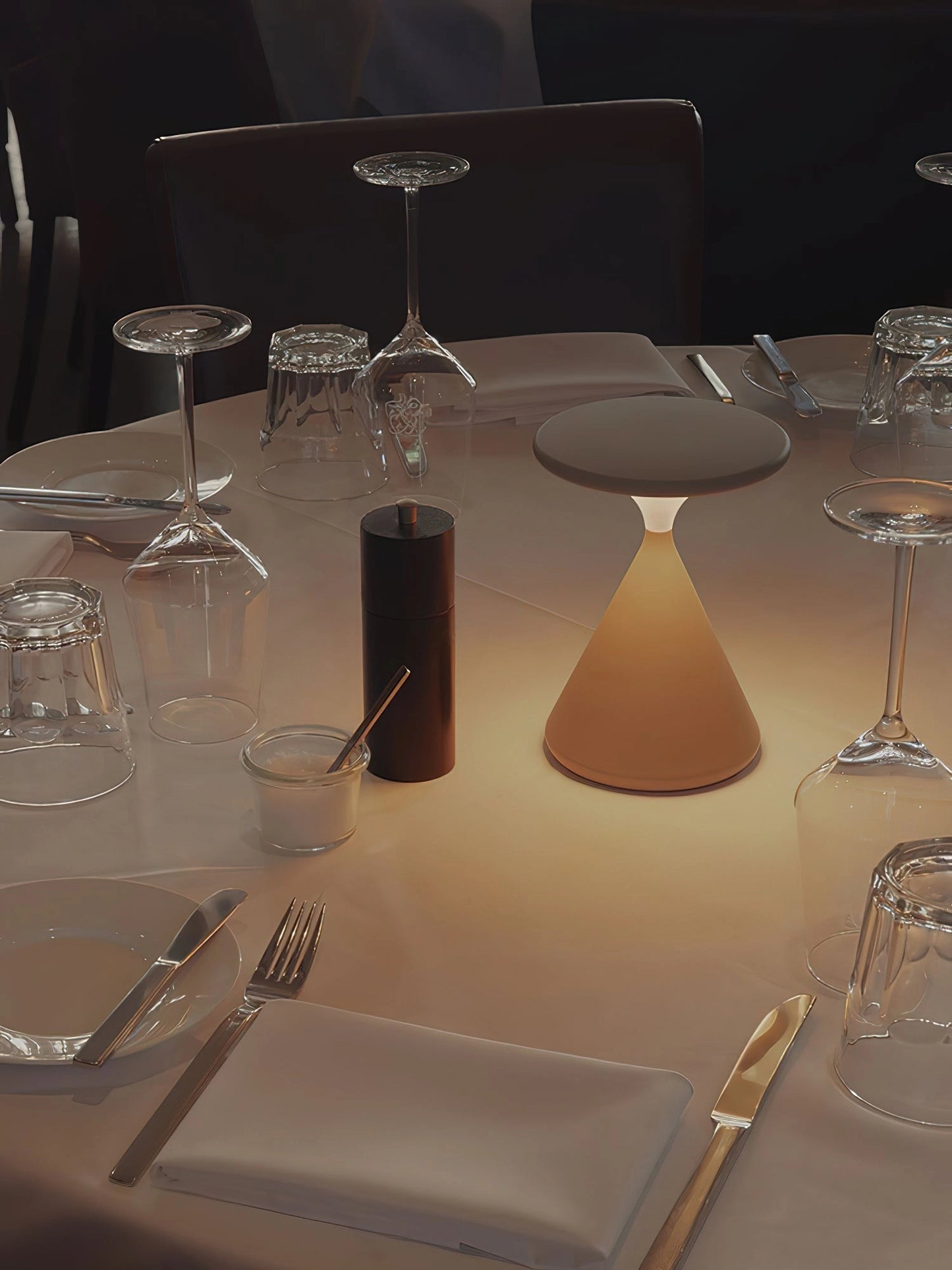 Outdoor Cordless Lamp for Portable Ambiance - Selene, placed on a table with various tableware, drinkware, and a wine glass, showcasing its versatility and elegance in an interior design setting.