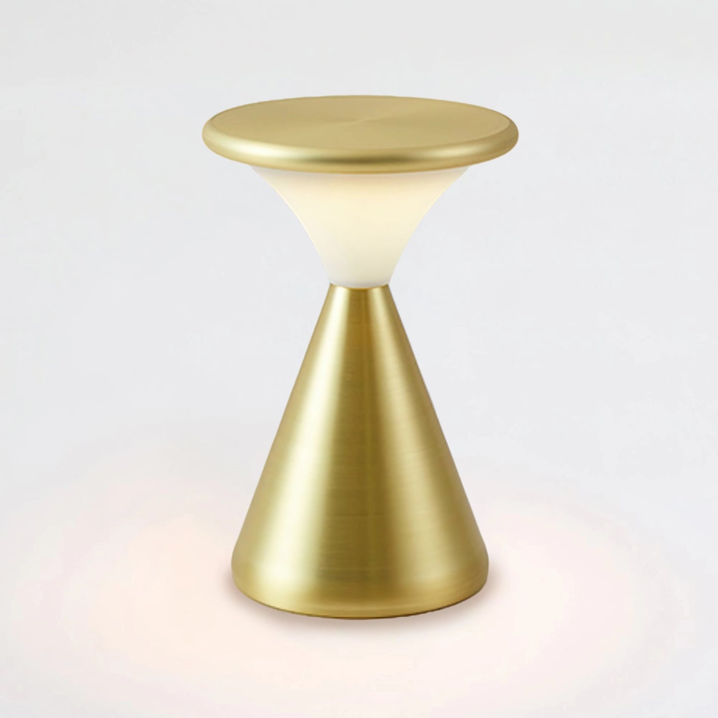 Outdoor Cordless Lamp for Portable Ambiance - Selene in Gold, Cool Light, placed on a wooden table with glass and metal elements nearby, versatile and elegant design for outdoor settings.