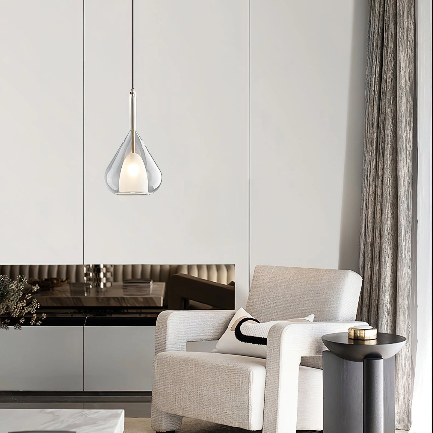 Pendant lamp with clear raindrop design and starlight effect, illuminating a modern Nordic-style living room featuring a grey couch, white table, and stylish interior elements.