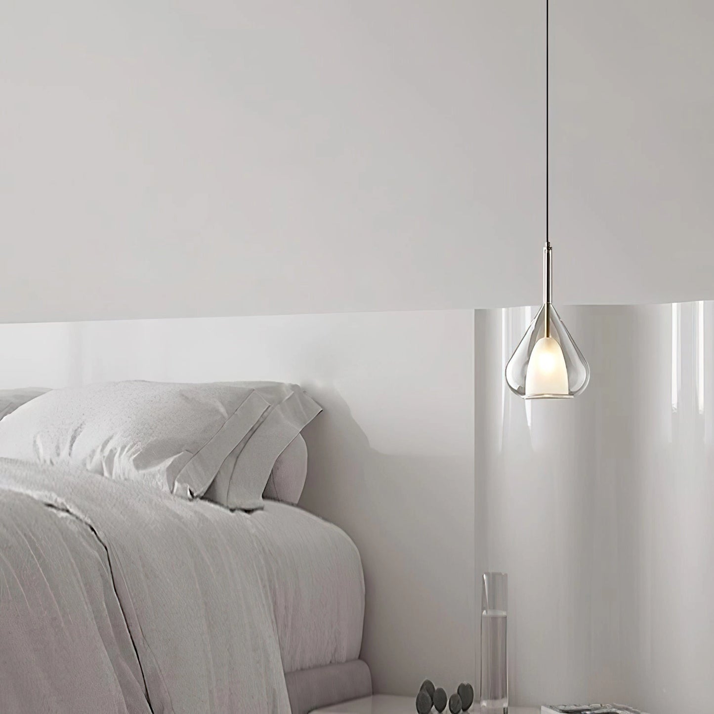 Nordic style pendant lamp with a clear raindrop design and starlight effect, hanging in a cozy interior with wooden and grey accents.