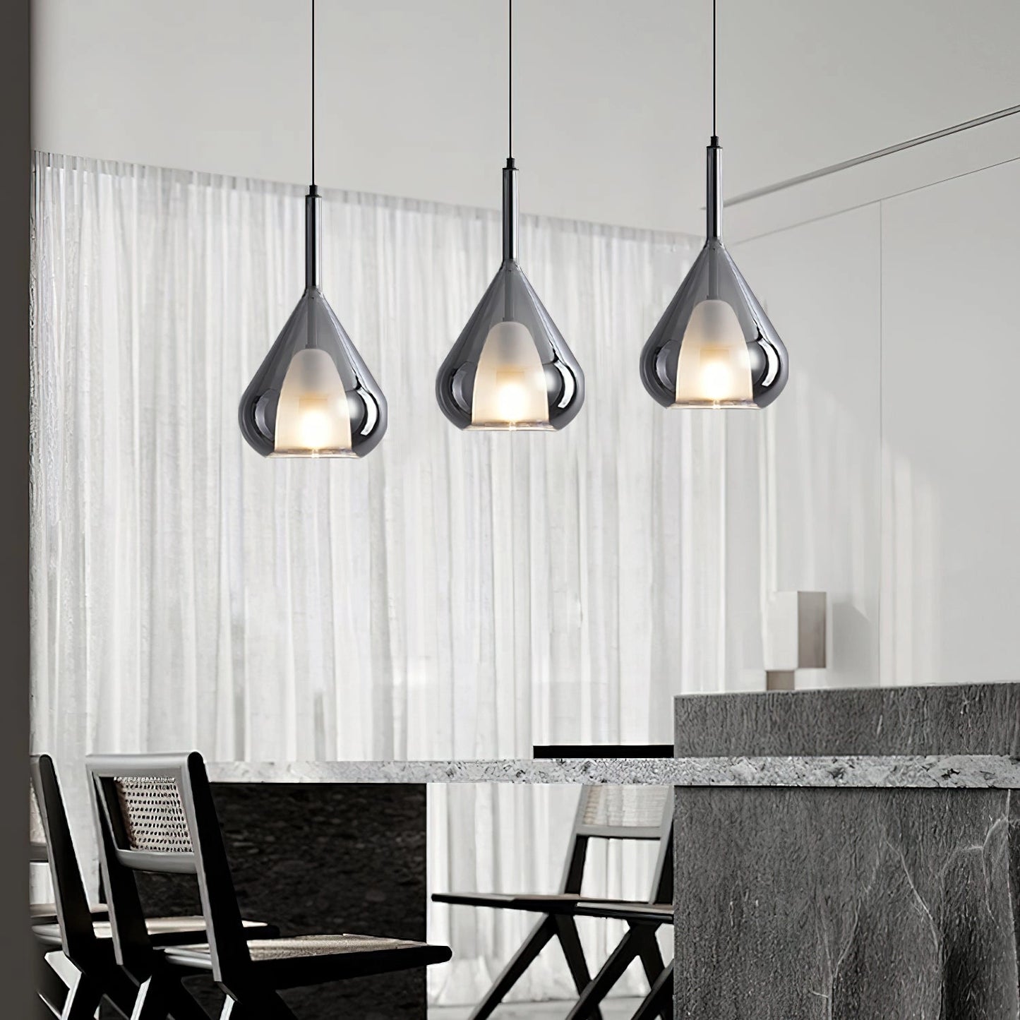 Nordic style pendant lamp with a clear raindrop design and starlight effect, hanging over a wooden table with grey chairs, featuring a monochrome interior design setting.