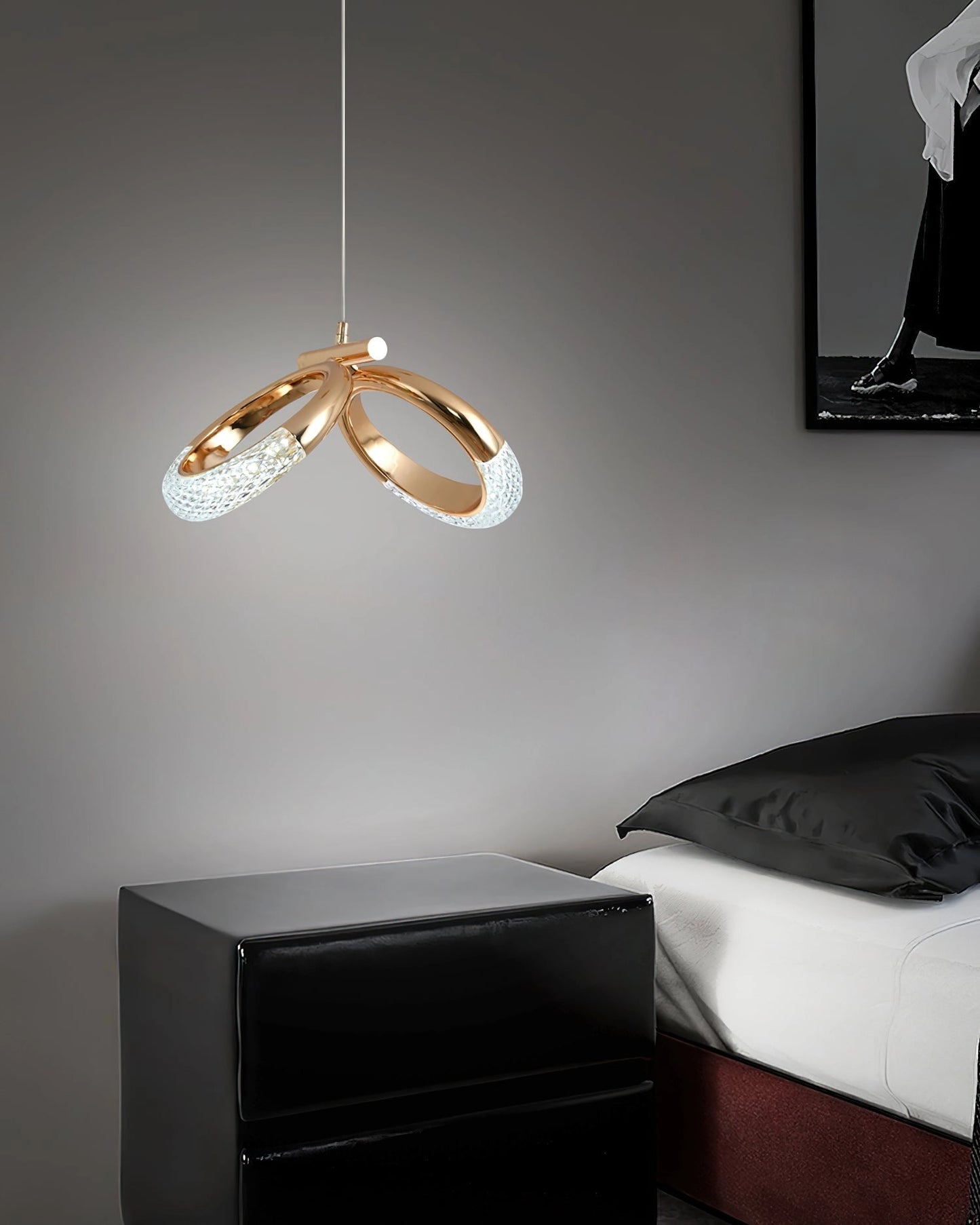 Modern pendant lamp Dante chandelier in white and black, illuminating a comfortable living room with a grey couch and wooden accents.