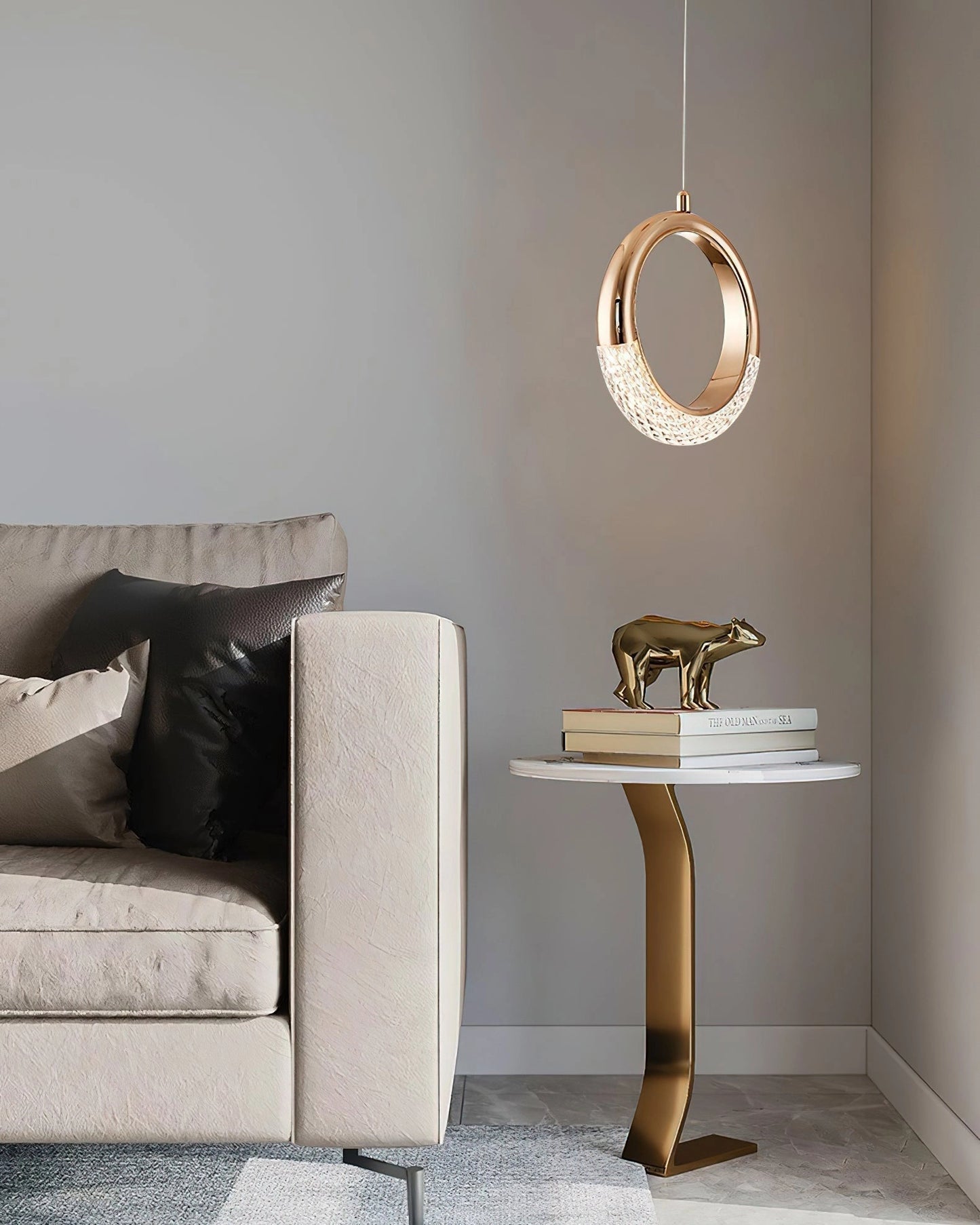 Modern beige and grey pendant lamp Dante hanging above a stylish living room setup featuring a wooden table, a grey couch, and contemporary interior design elements.