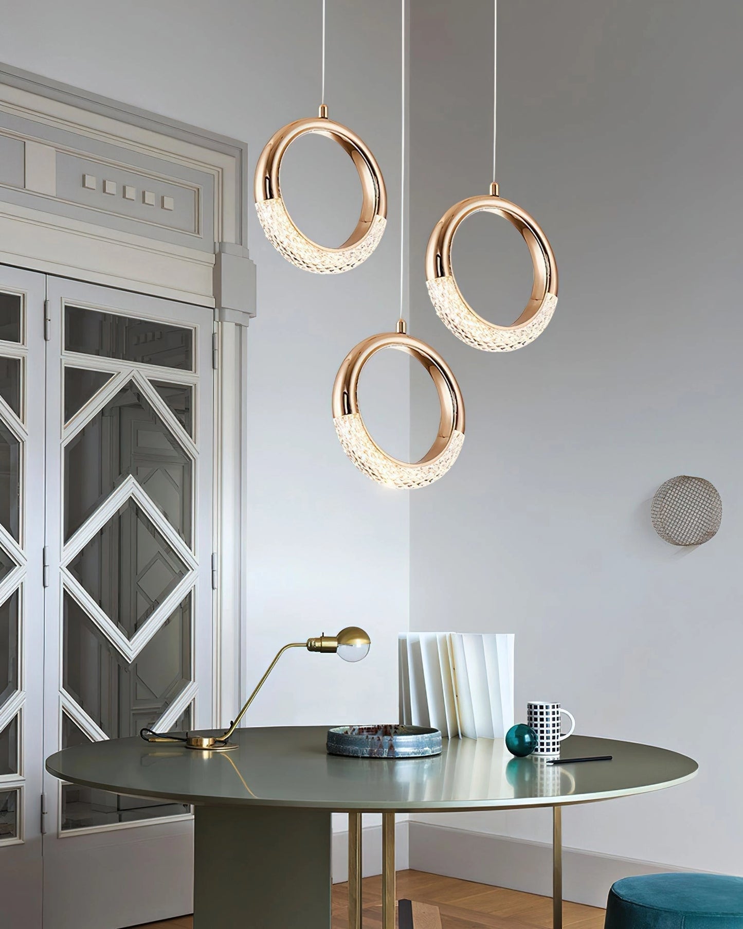 Modern white pendant lamp Dante hanging above a wooden table in a minimalist interior setting with clean lines and contemporary furniture.