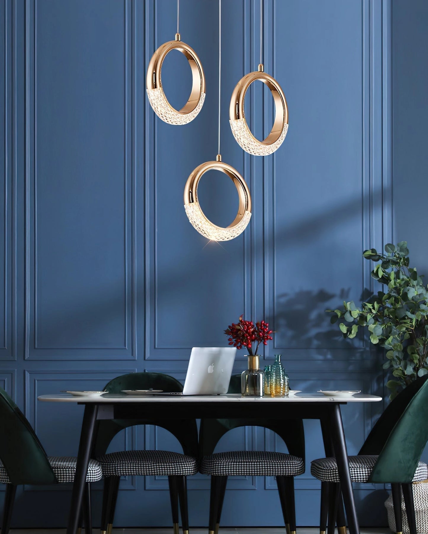 A modern pendant lamp chandelier hanging above a table with surrounding furniture, plants, and a window in a well-lit interior design setting.