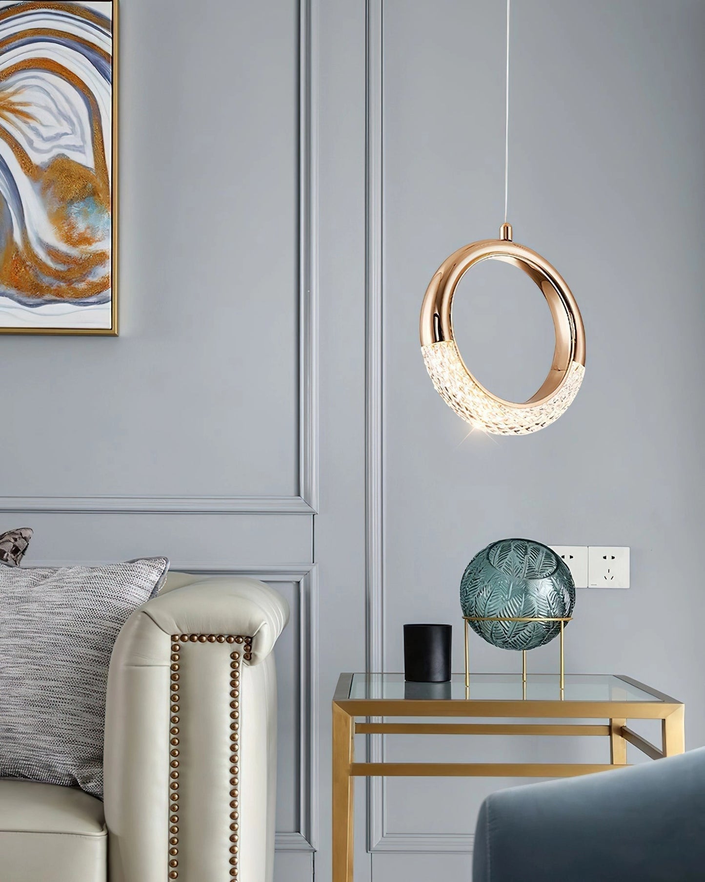 Modern Pendant Lamp Dante hanging from the ceiling in a stylish living room with contemporary furniture, including a couch and picture frames on the wall.