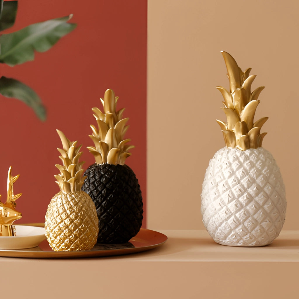 Golden resin pineapple-shaped ornament for Nordic home decor placed on a table.