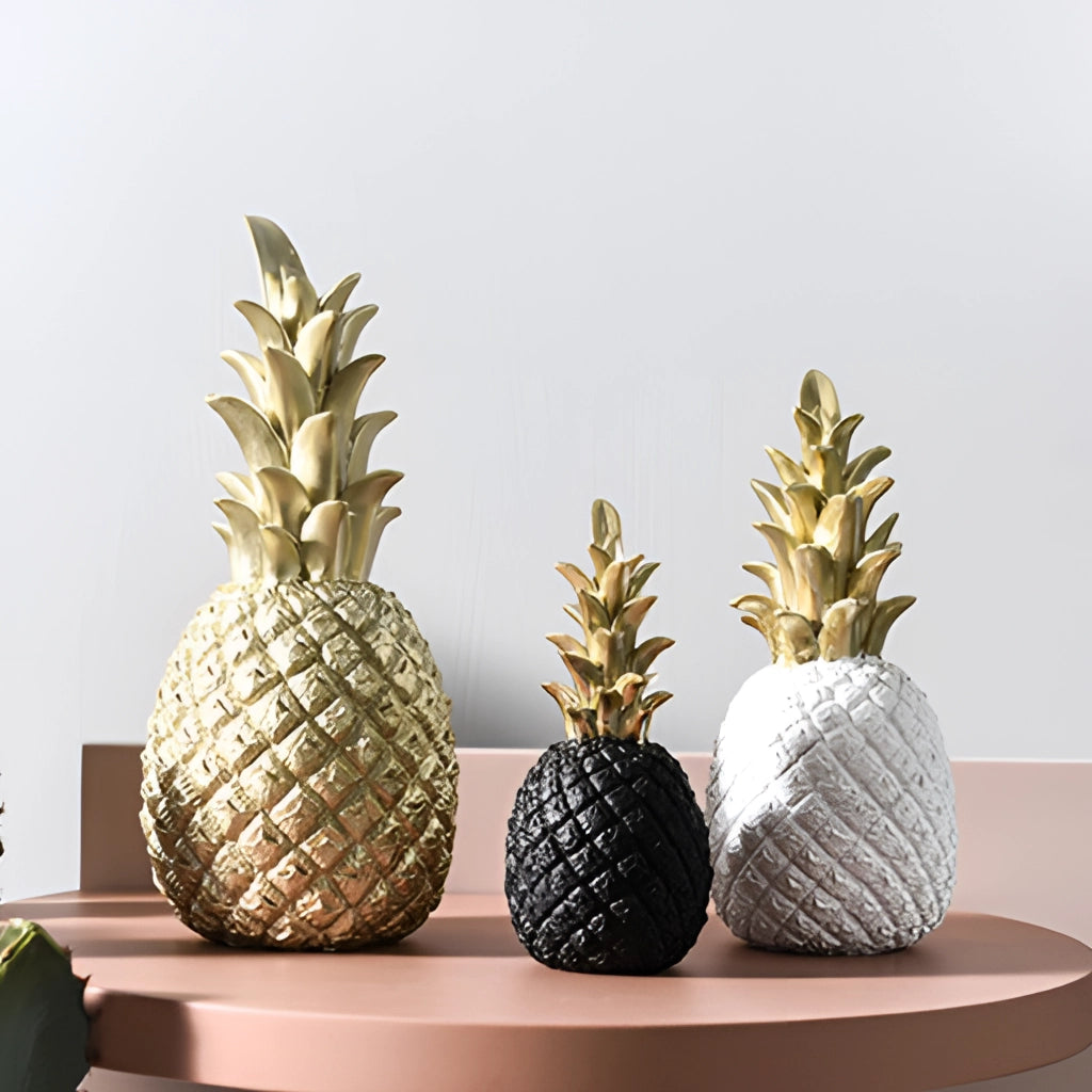 Golden resin pineapple-shaped ornament resembling natural fruit, designed for Nordic-style home decor, displayed on a wooden rectangular base.