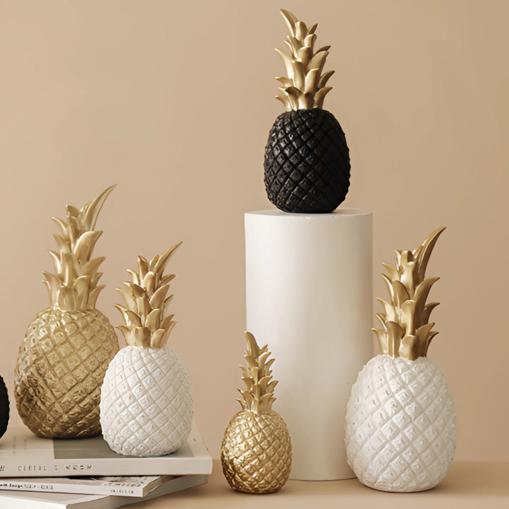 Golden resin pineapple-shaped ornament on a white surface, used as Nordic home decor.