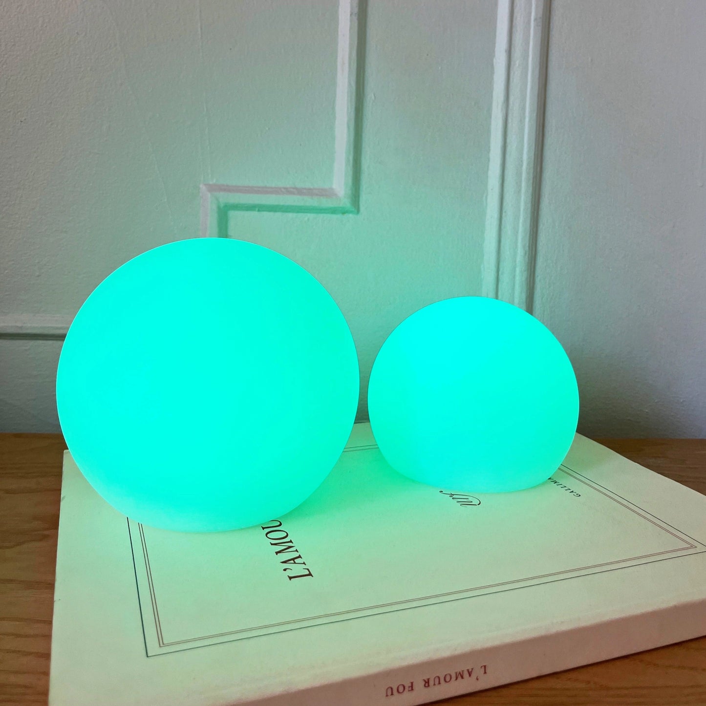 Rechargeable Cordless LED Moon Table Lamp with 16 Color Options, shown on a table emitting an electric blue light.