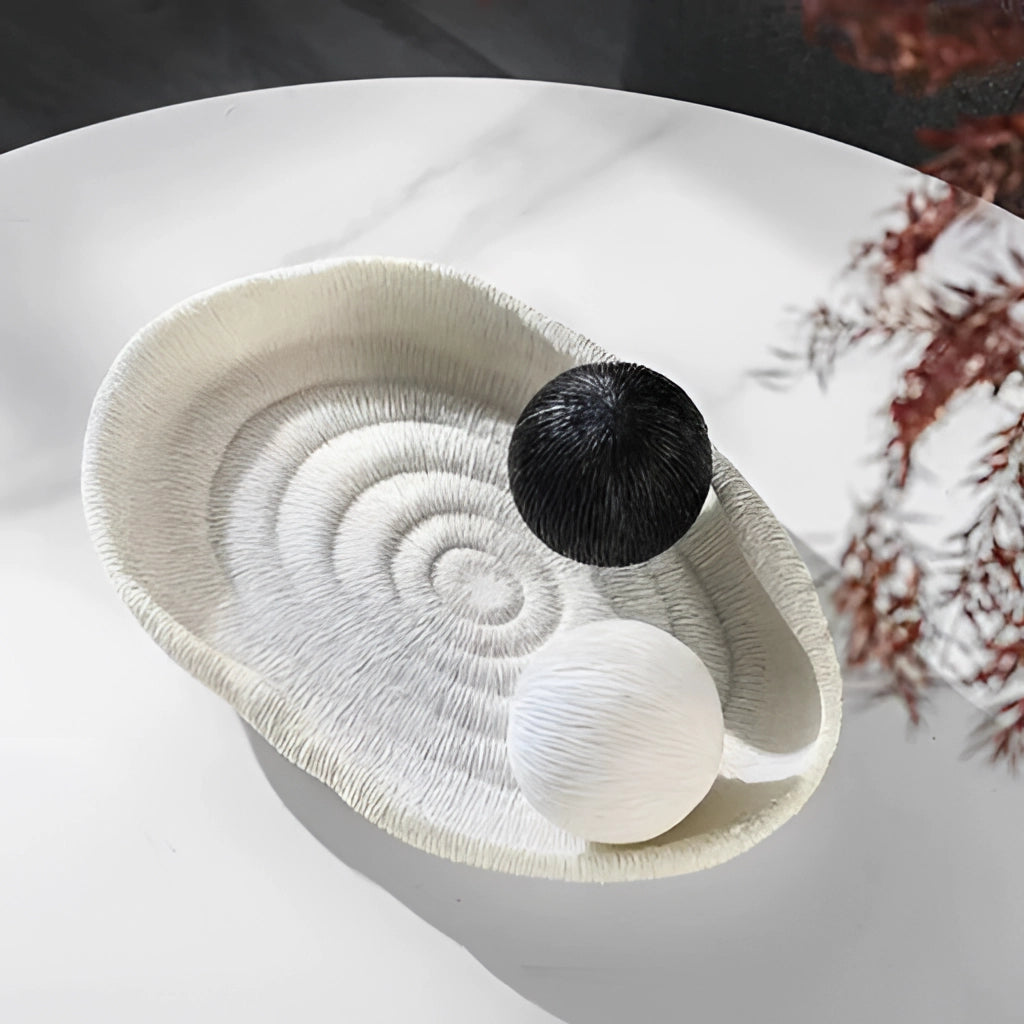 A nature-inspired decorative bowl made of resin, featuring intricate bird and feather designs, circular shape, and natural material aesthetic.