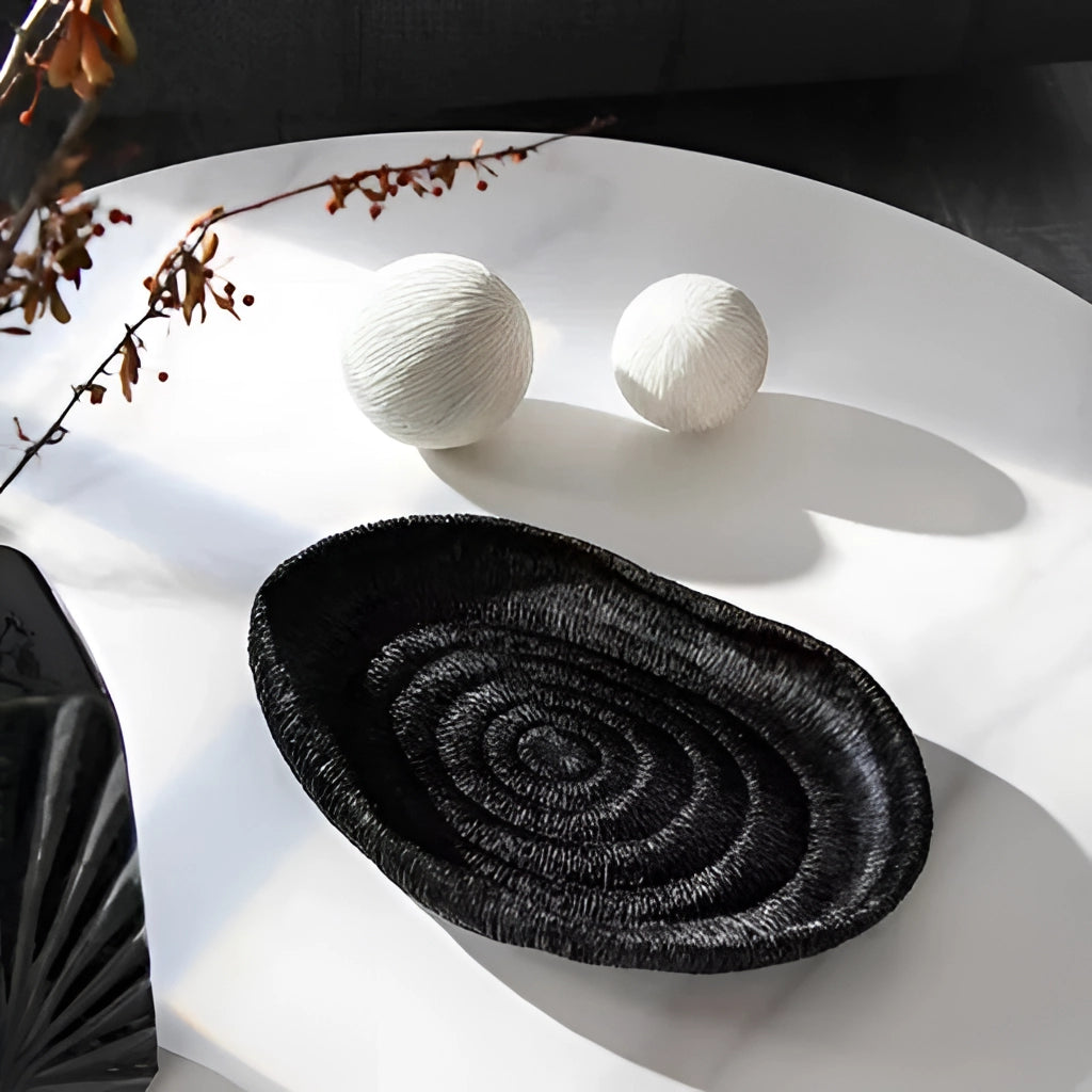 Nature-inspired resin decorative bowl on a grey table, featuring intricate artistic design and circular shape.