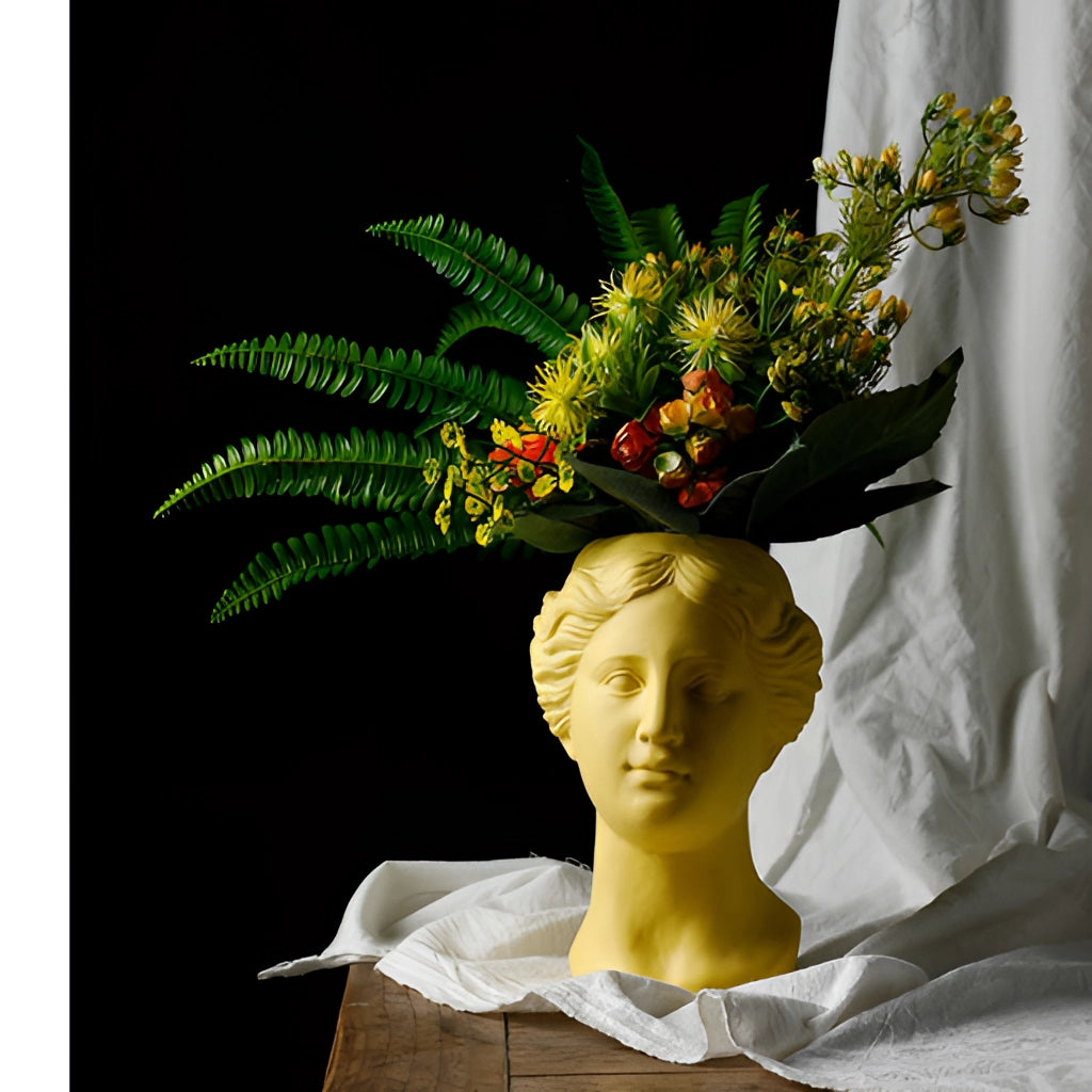 Resin Neoclassical Venus Vase in Blush Pink filled with a bouquet of artificial flowers.