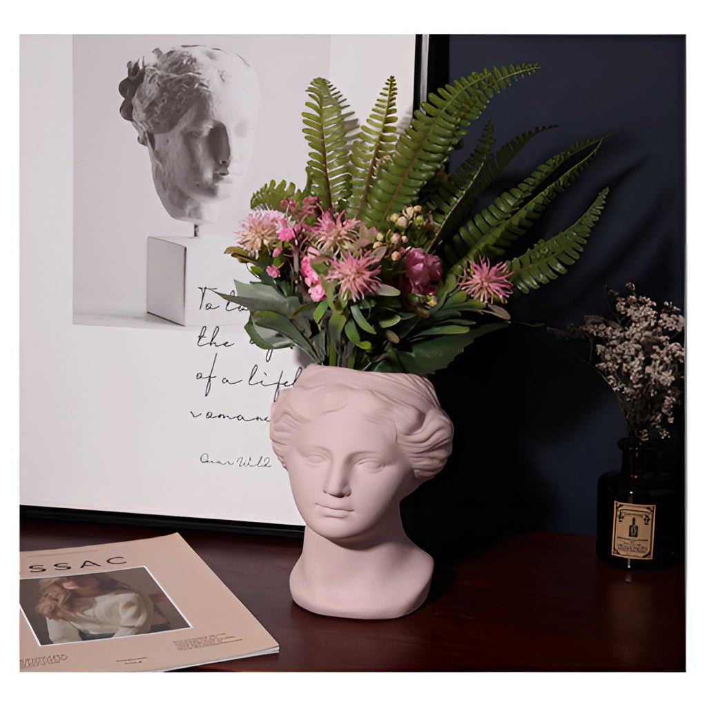 Resin Neoclassical Venus Vase in Blush Pink with flowers and houseplants, showcasing interior design and art elements.