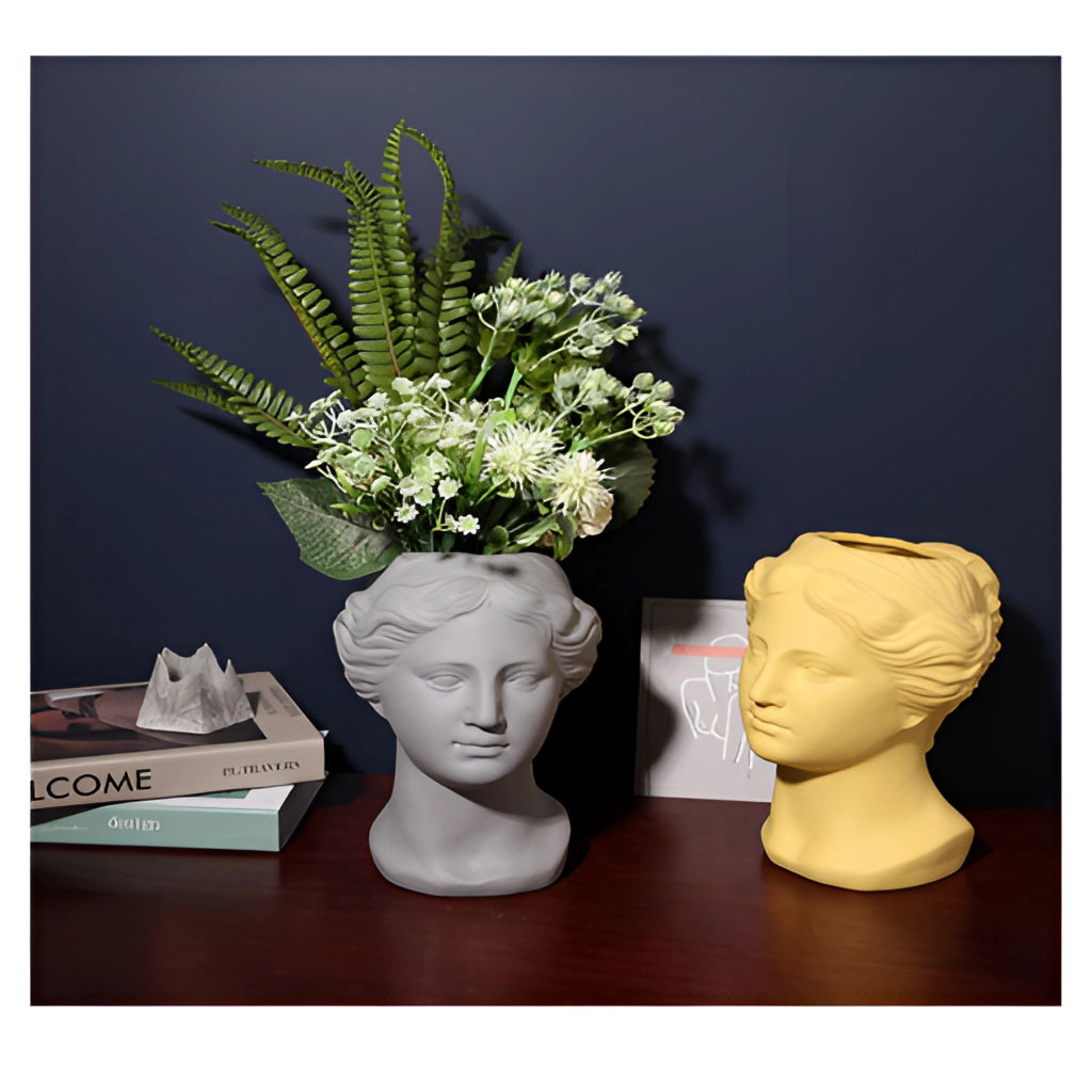 Resin Neoclassical Venus Vase in Blush Pink with a plant.