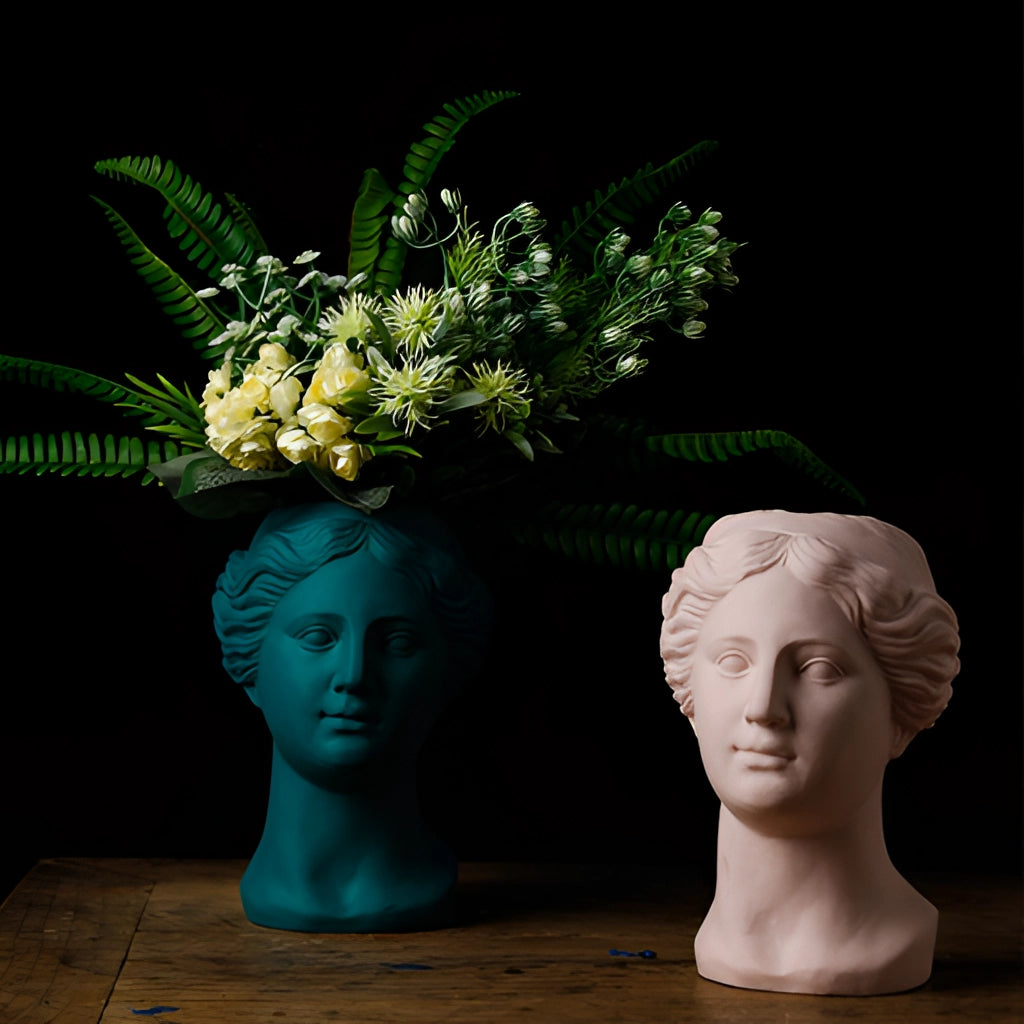 Neoclassical Venus vase made of resin in blush pink color, used as a flowerpot with plants, showcasing a blend of classical art and modern decor.