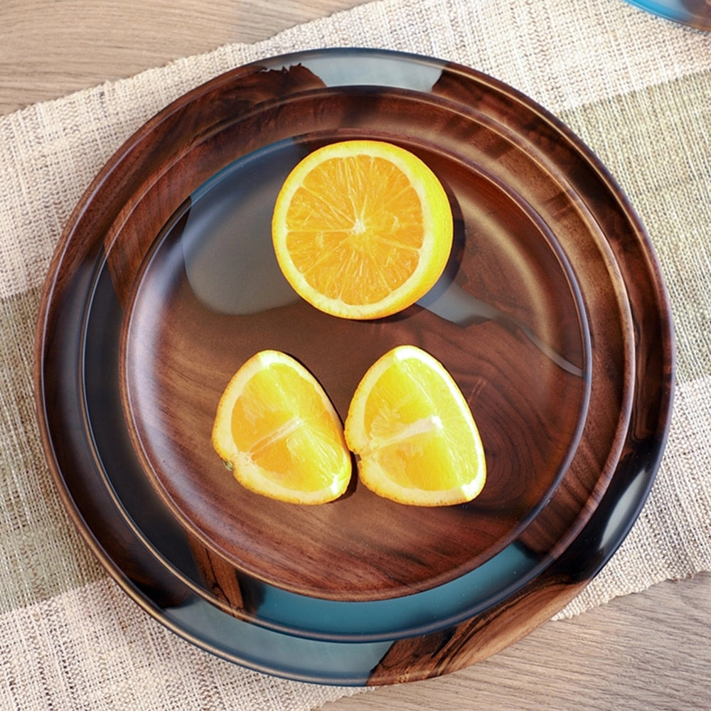 Handcrafted epoxy resin wood tray with a variety of fruits including Valencia oranges, clementines, and bitter oranges, displayed as tableware on a surface.