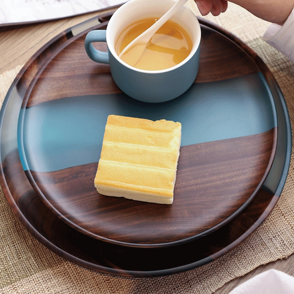 Handcrafted epoxy resin wood tray with an assortment of cheeses and ingredients placed on it, showcasing its use as elegant serveware.