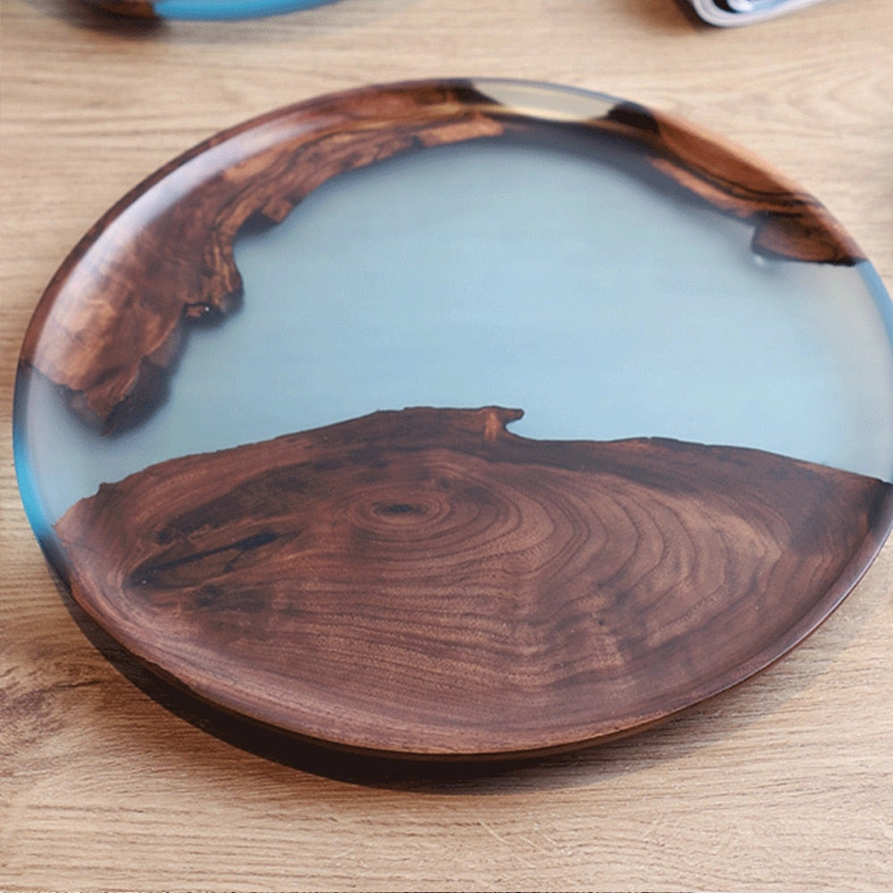 Handcrafted epoxy resin wood tray with a circular design, featuring natural wood grain and epoxy resin accents, displayed on a table.