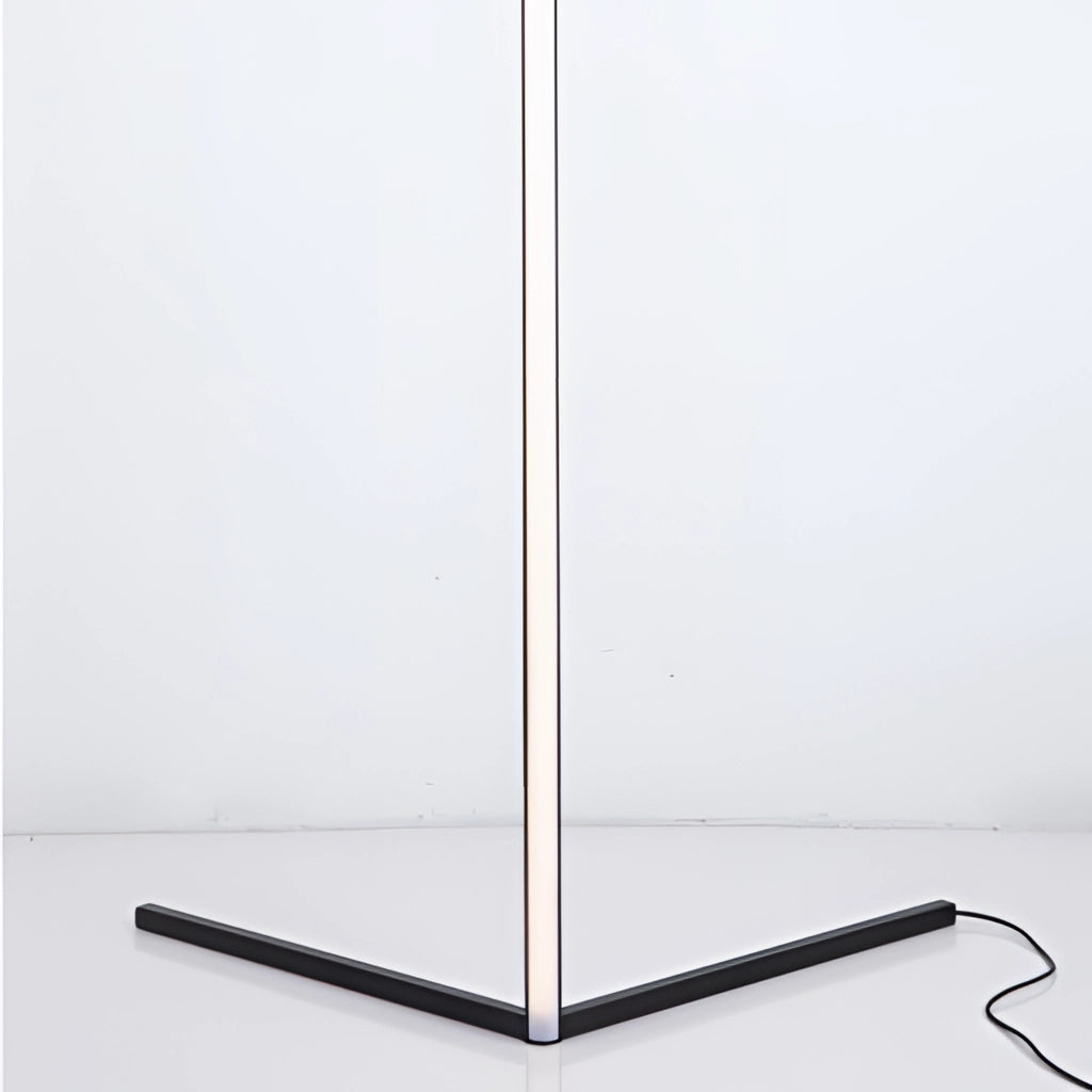 Modern RGB Corner Floor Lamp with LED light, remote control resting on a sleek wooden floor against a white wall, emitting colorful lights.